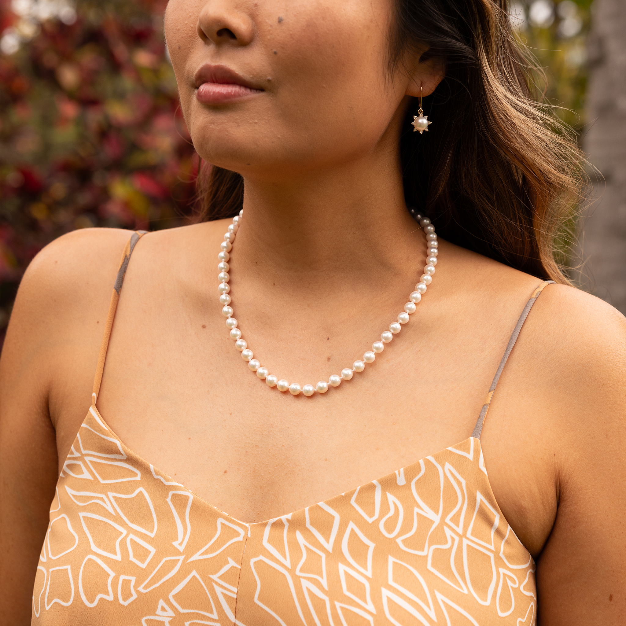 Close-up of a woman wearing an Akoya white pearl strand necklace