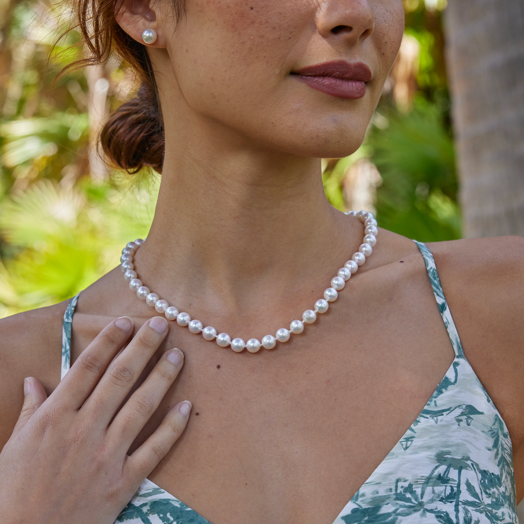 Close-up of a woman wearing an Akoya white pearl strand necklace