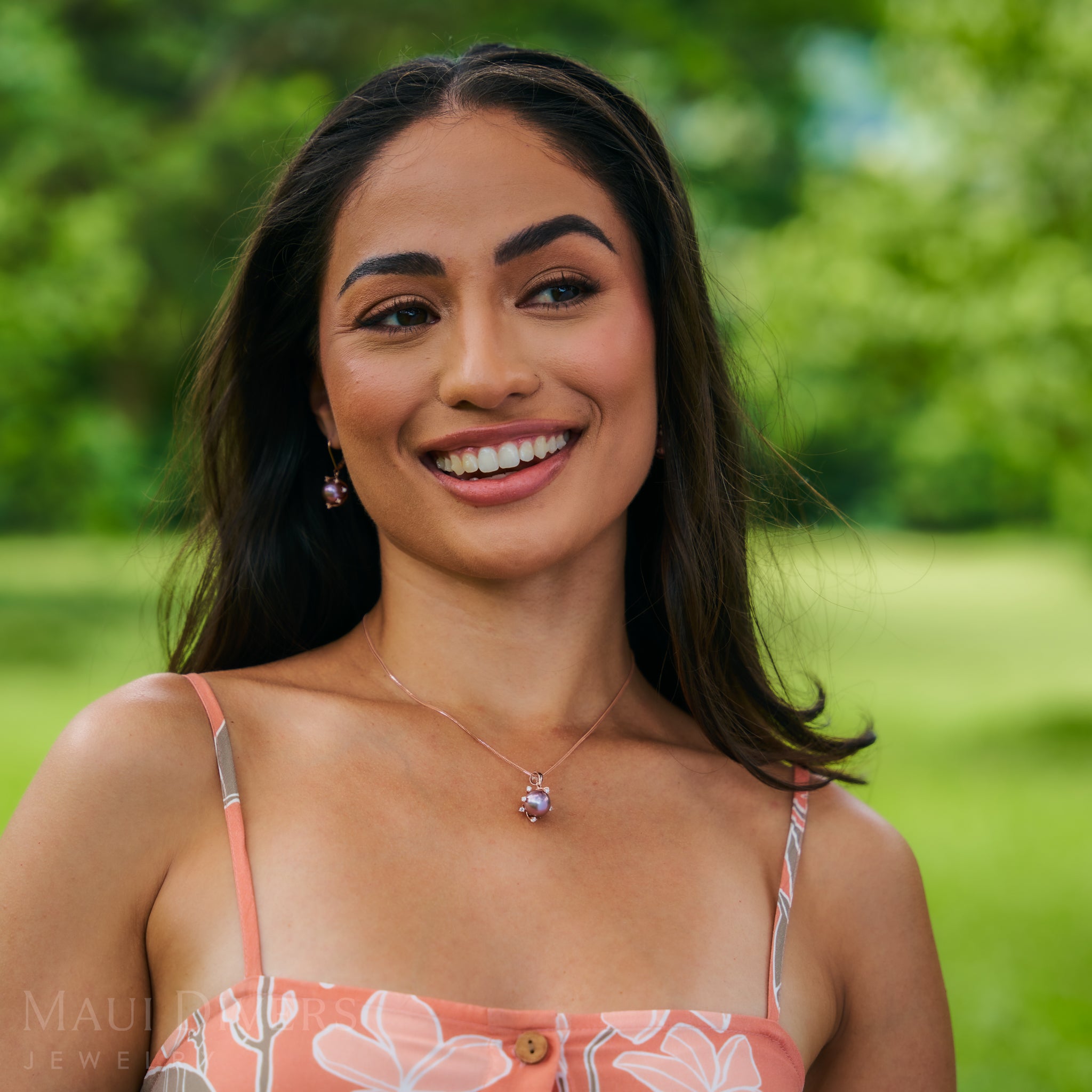 Woman in a garden wearing 1.2mm Singapore Foxtail Chain in 14k Rose Gold with a pearl pendant