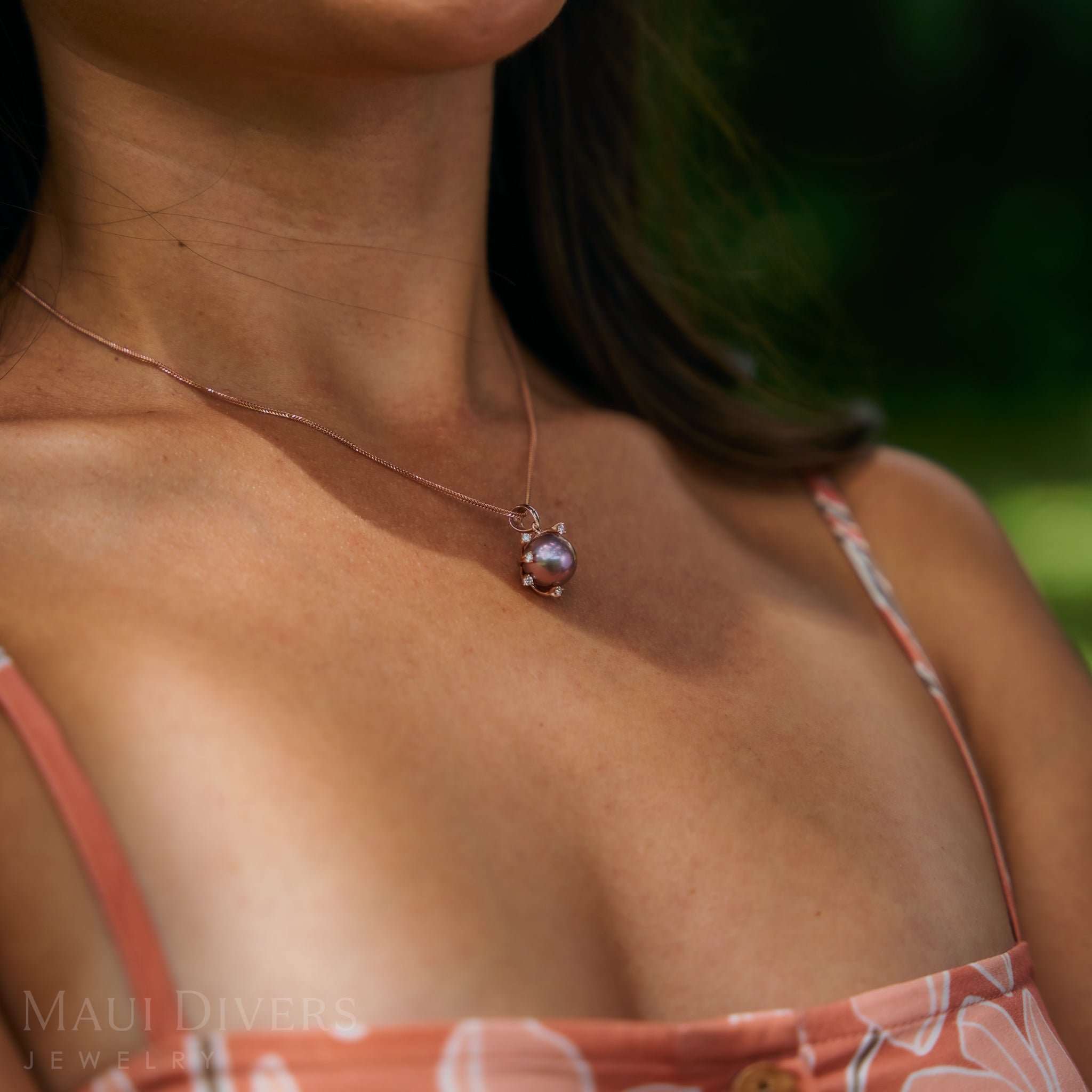 Close up of a womanʻs chest wearing 1.2mm Singapore Foxtail Chain in 14k Rose Gold with a pearl pendant