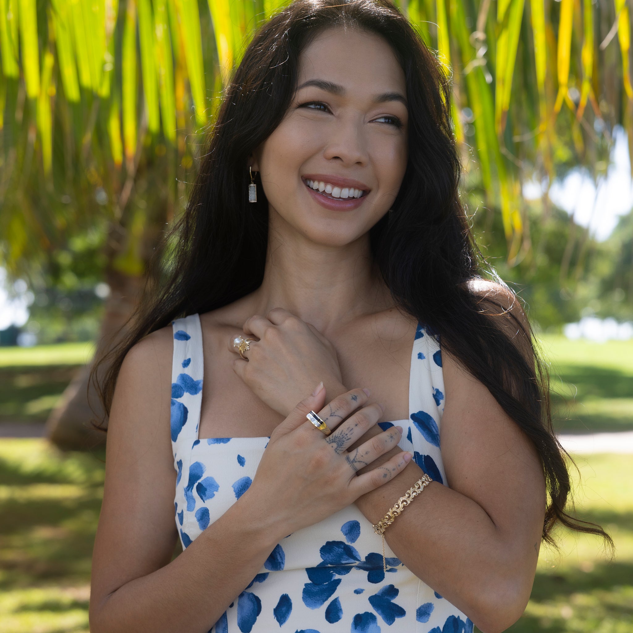 Woman in a beach park wearing Black Coral Ring in Gold with Mother of Pearl