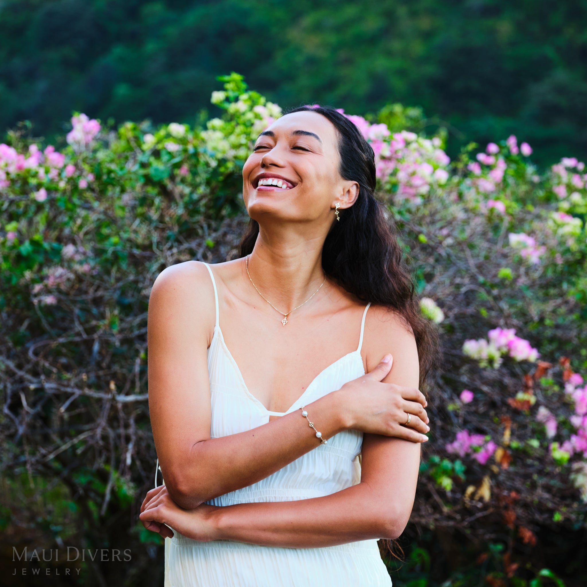 Woman in a garden wearing Hawaiian Quilted Star Akoya White Pearl Bracelet in Gold with matching Earrings and Pendant