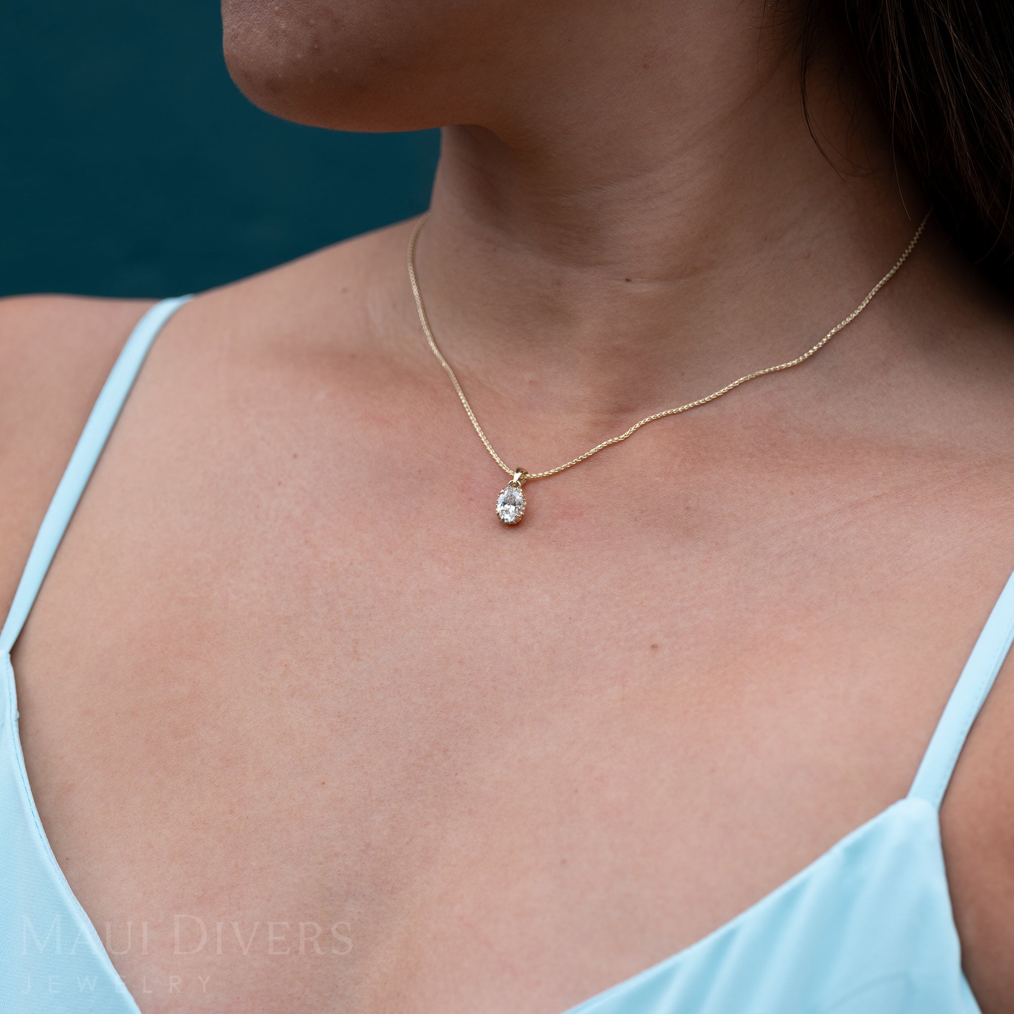 Close up of woman wearing a Hidden Hawaiʻi Maile Lab Grown Diamond Pendant in Gold