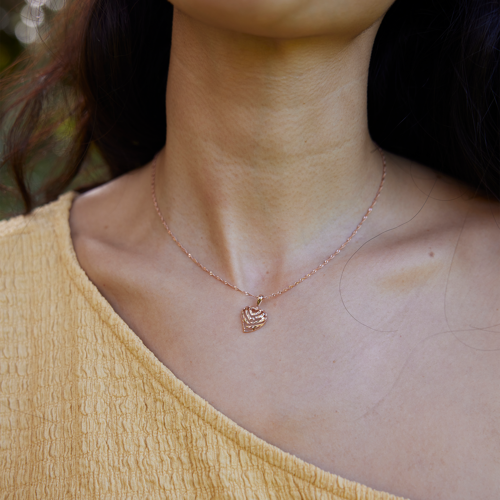 Close up of woman wearing Rose Gold Aloha Heart Pendant with diamond cut finish on Chain