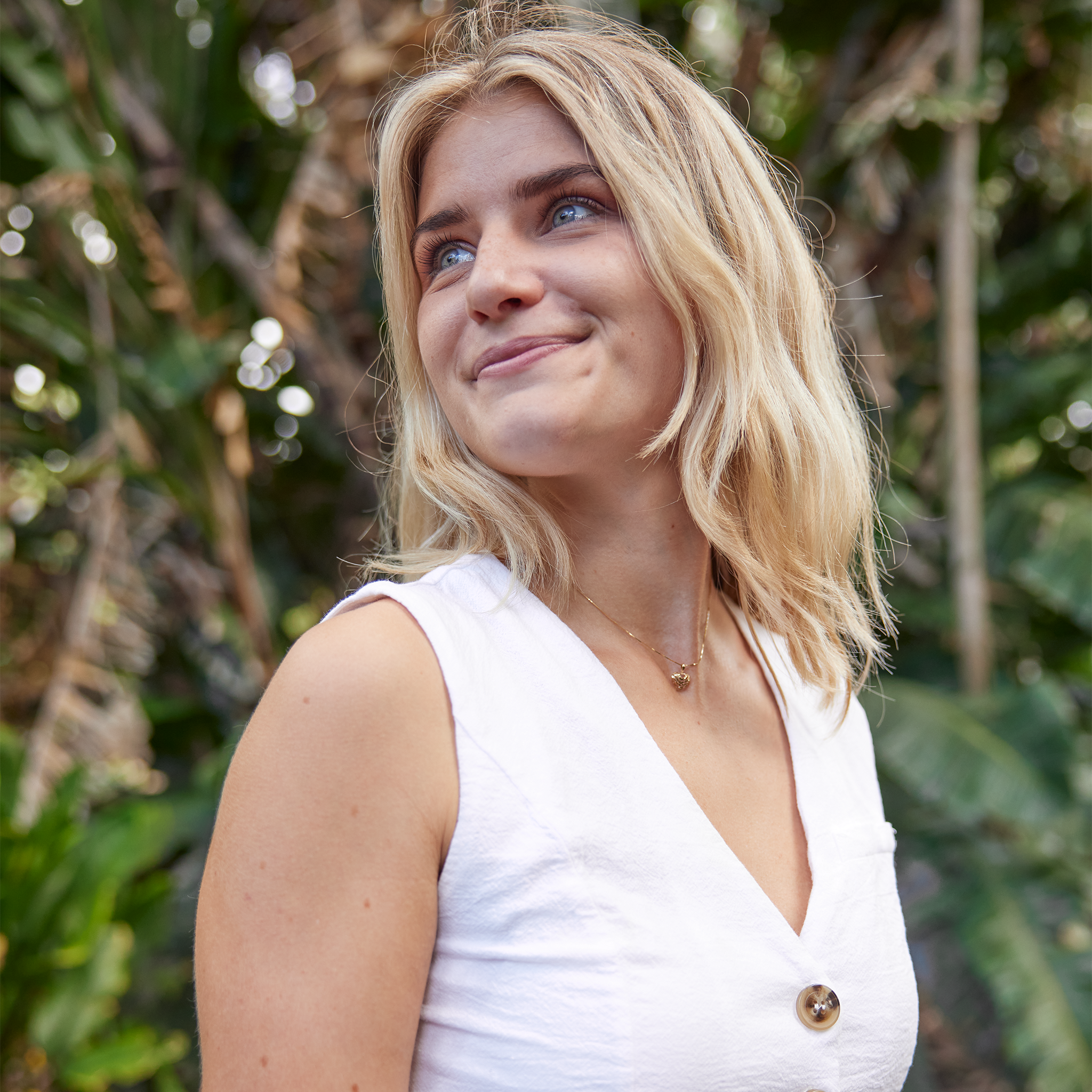 Woman smiling with nature background wearing Aloha Heart Pendant in Gold on chain