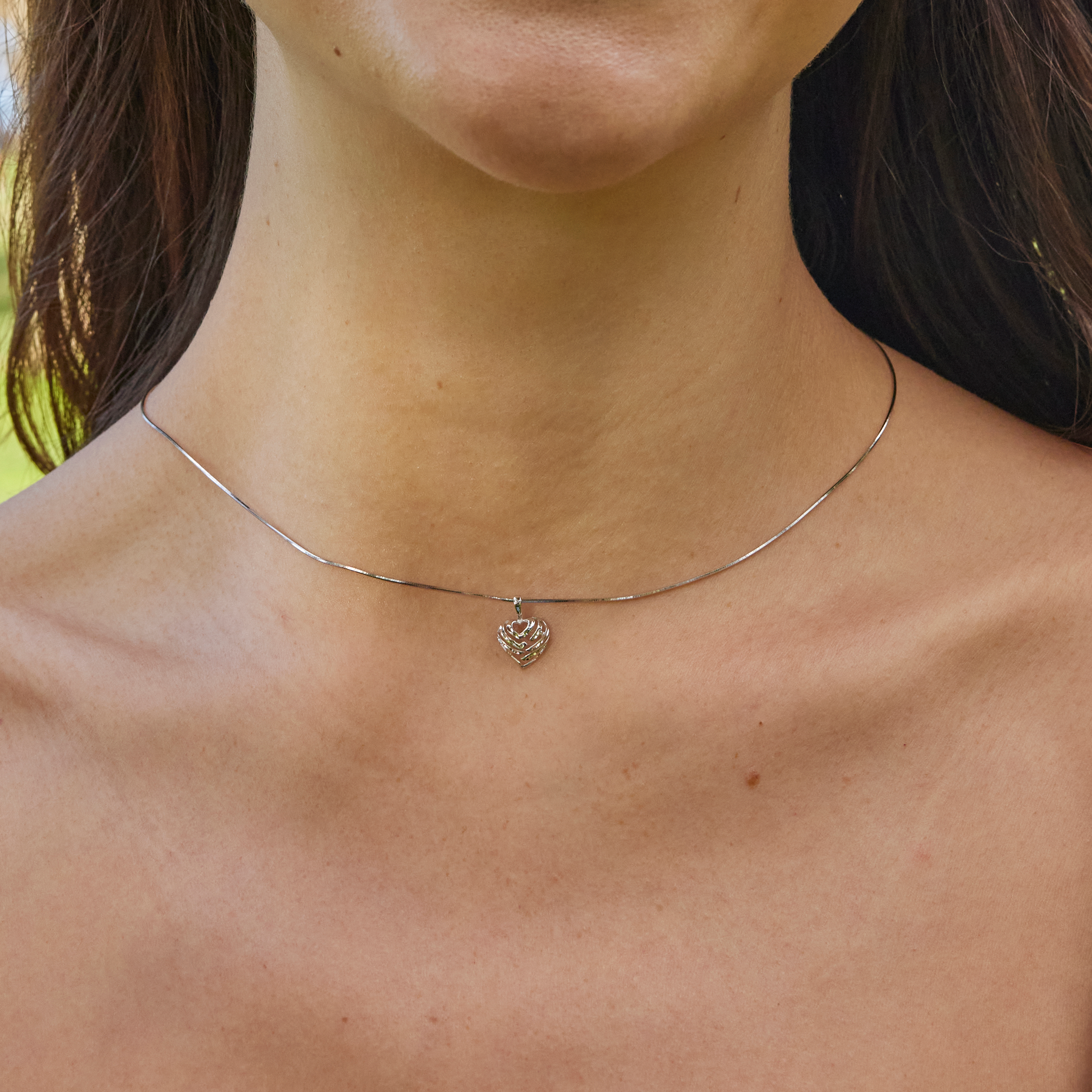 Neckline of a woman wearing baby box chain featuring white gold Aloha Heart Pendant