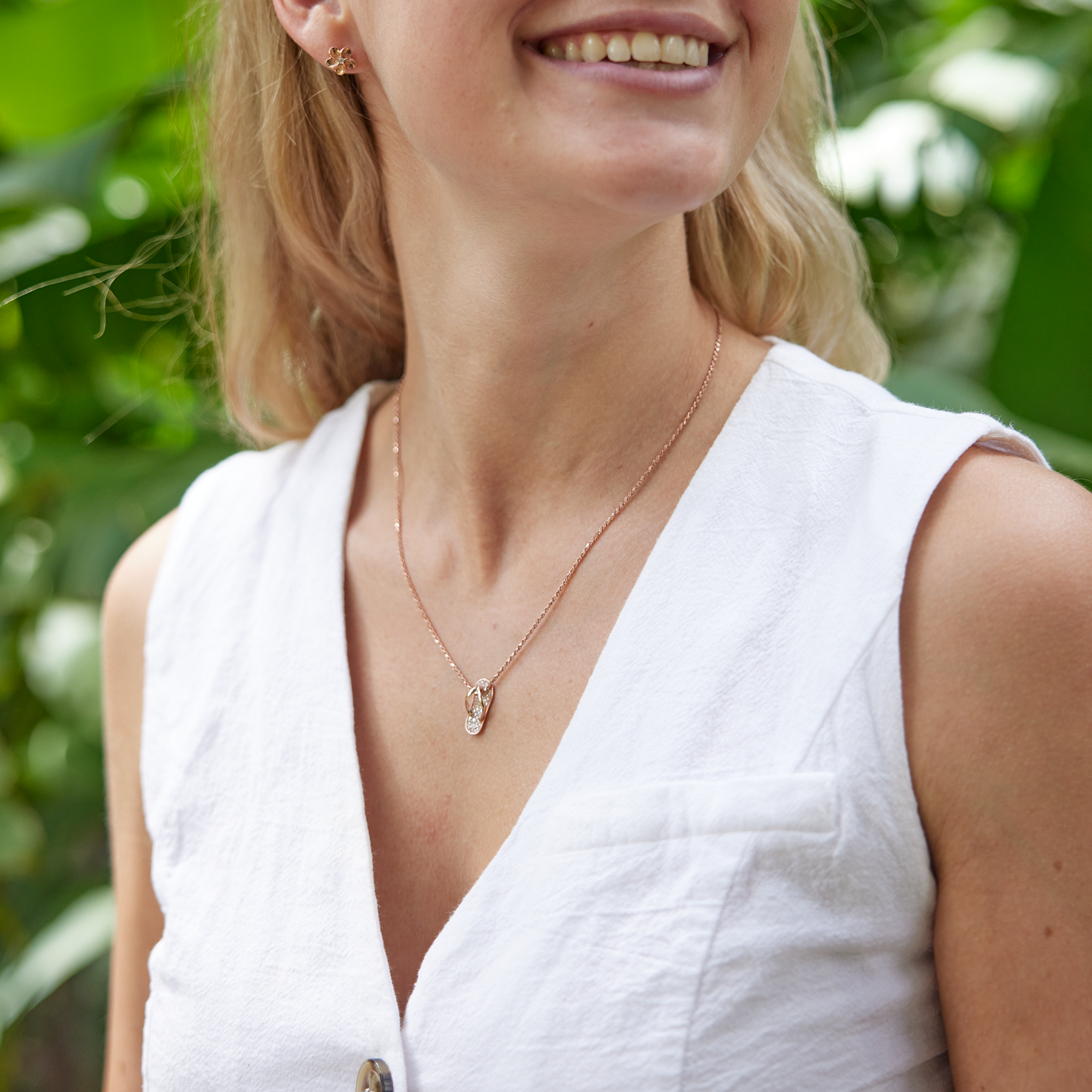 Woman in white shirt wearing Slipper Pendant in Rose Gold with Diamonds with nature background