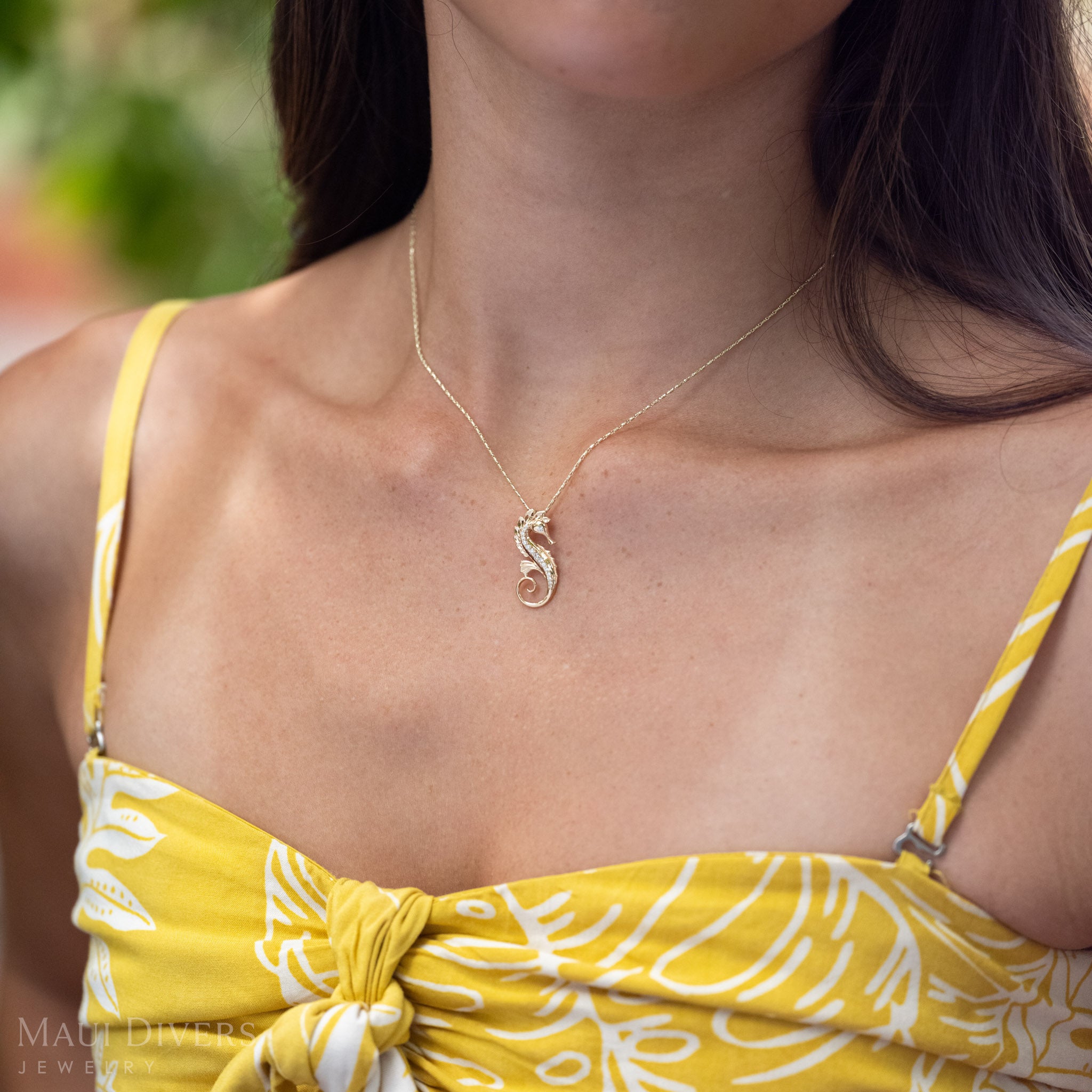 Close-up of a 14k Gold Seahorse Necklace with Natural Diamond detailing.