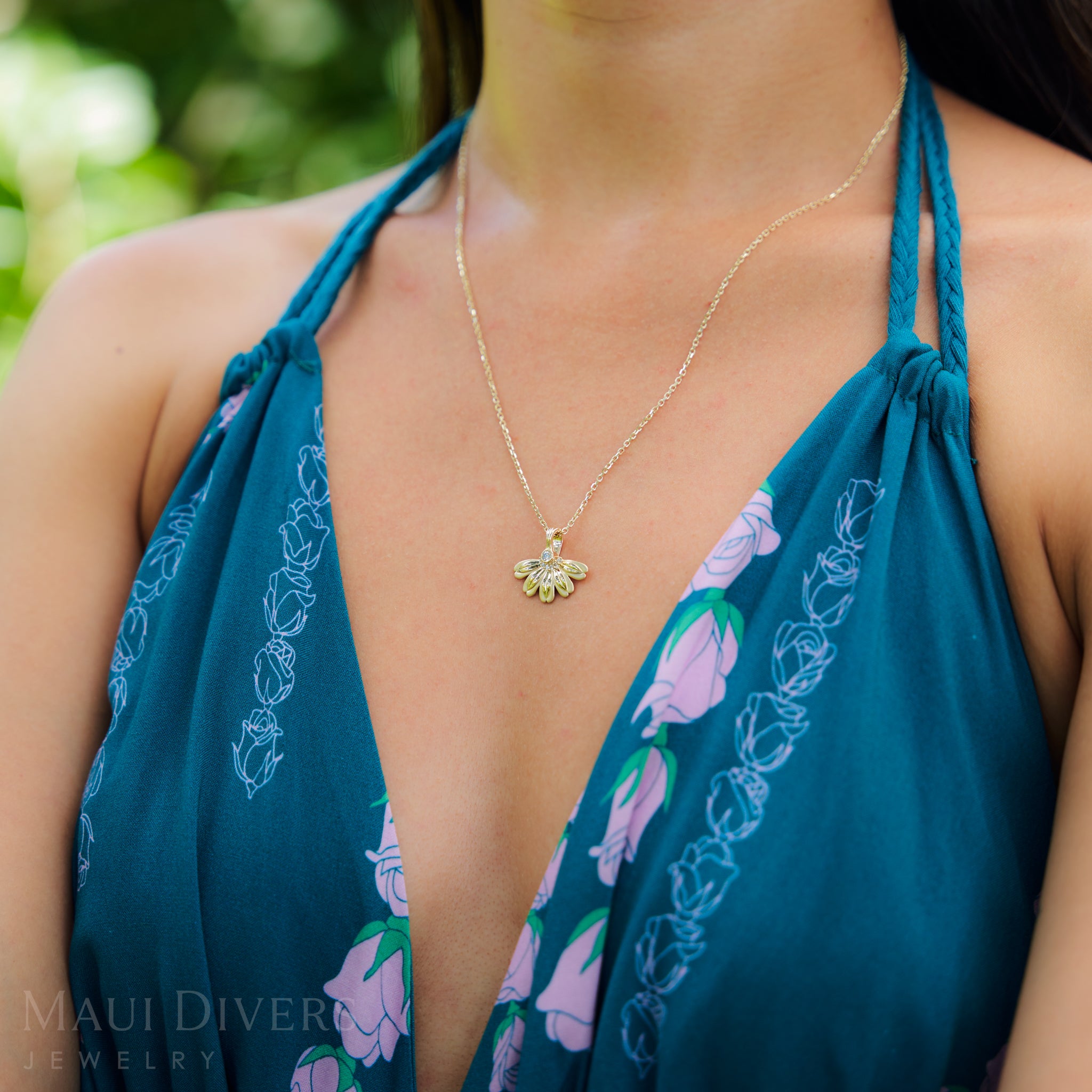 Woman wearing a blue dress and Beach Naupaka Pendant in Gold with Diamonds