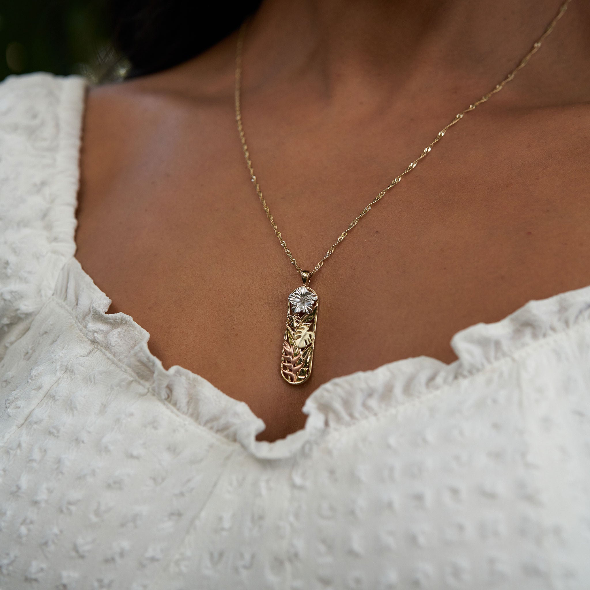 Close up of woman wearing Hawaiian Gardens Hibiscus Pendant in Multi Color Gold with Diamonds