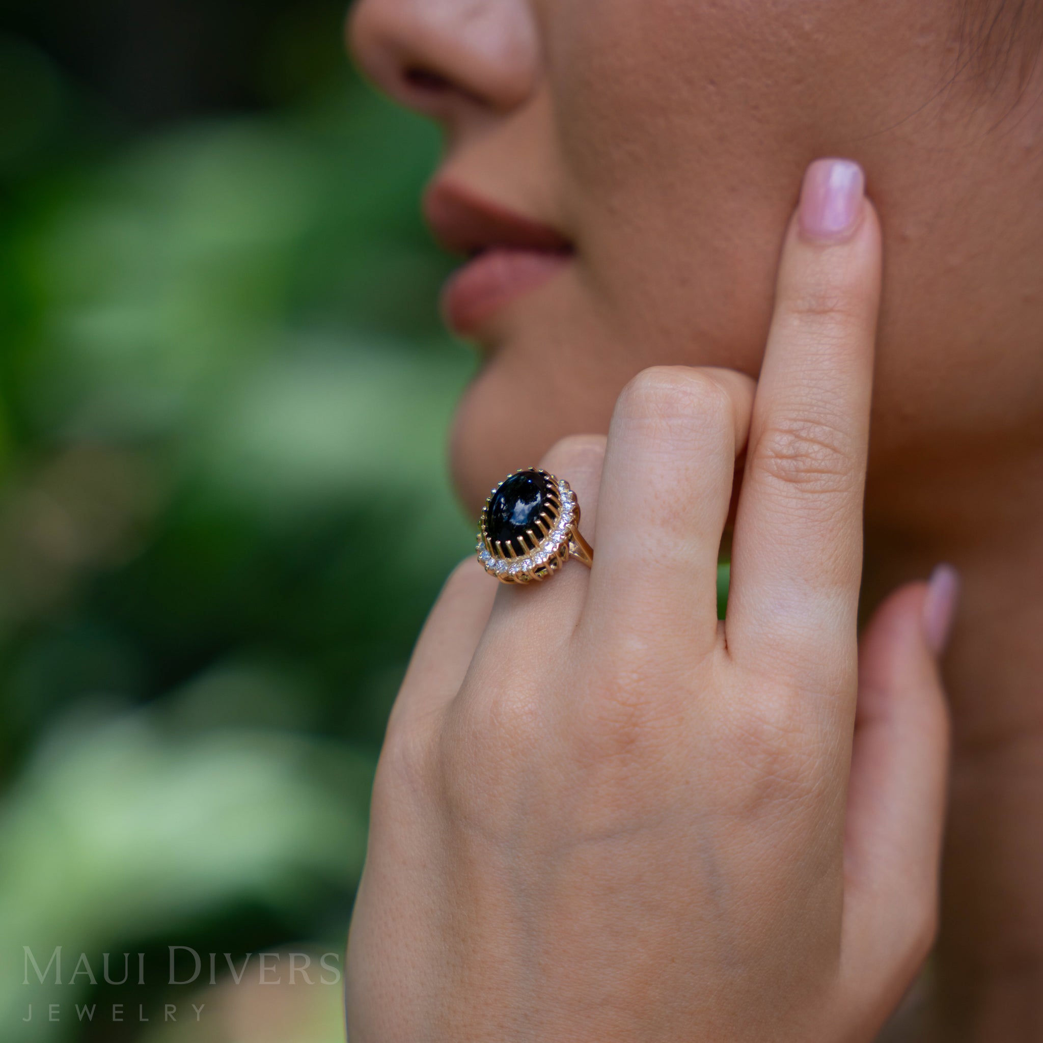 Close-up of a hand wearing a Princess Ka‘iulani Hawaiian Black Coral Ring in Gold with Diamonds