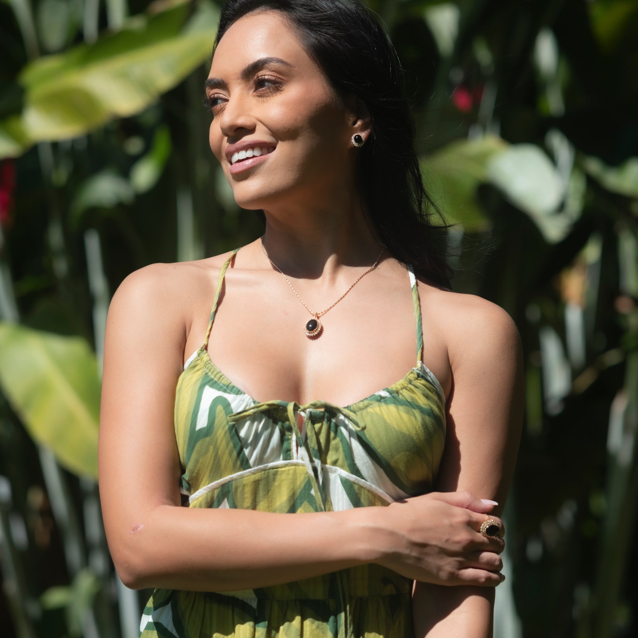 Woman in a tropical garden wearing a Princess Ka‘iulani Hawaiian Black Coral Ring in Gold with Diamonds