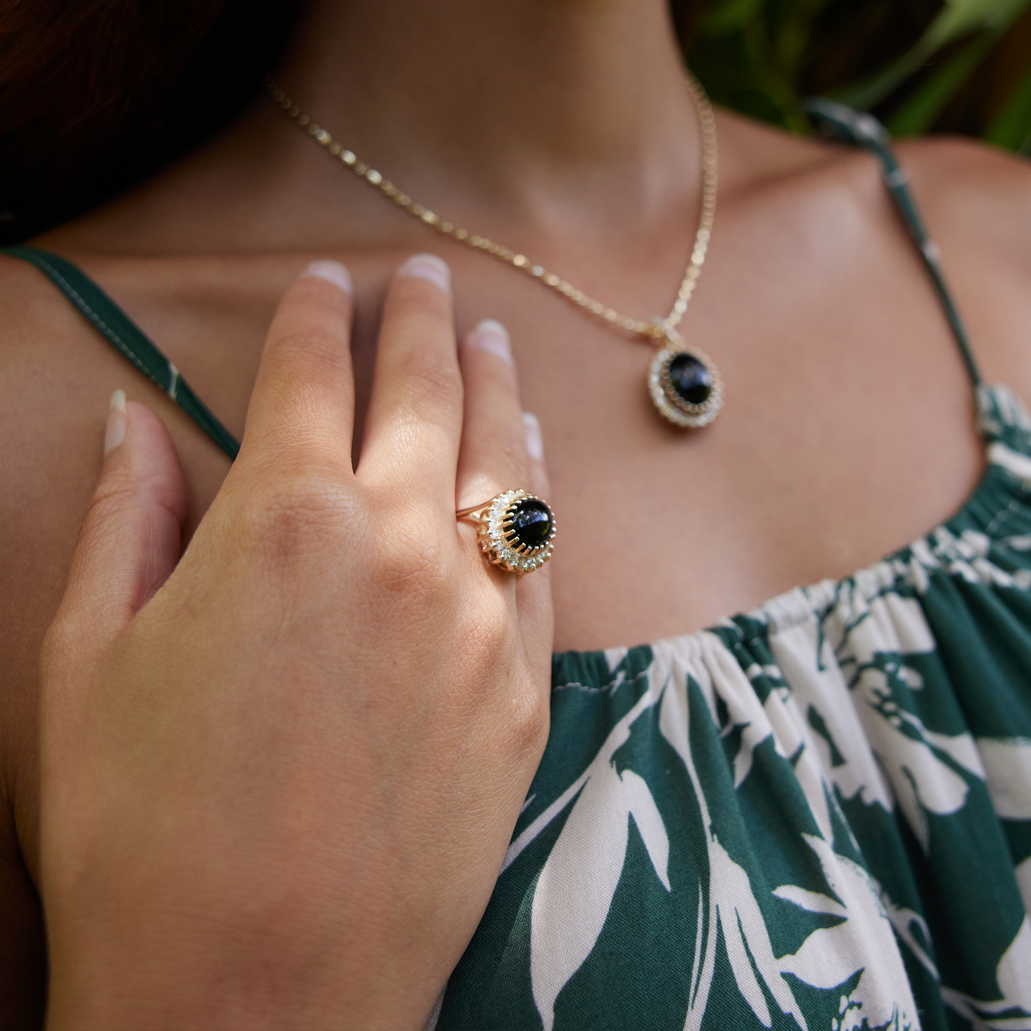 Close up of woman wearing Princess Ka‘iulani Black Coral Ring and pendant in Gold with Diamonds