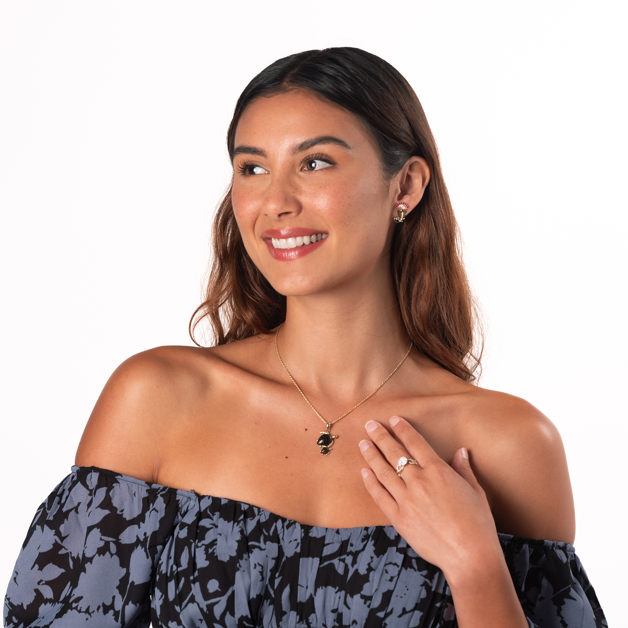 A woman in a studio wearing a Honu Mom & Baby Black Coral Pendant in 14k Yellow Gold
