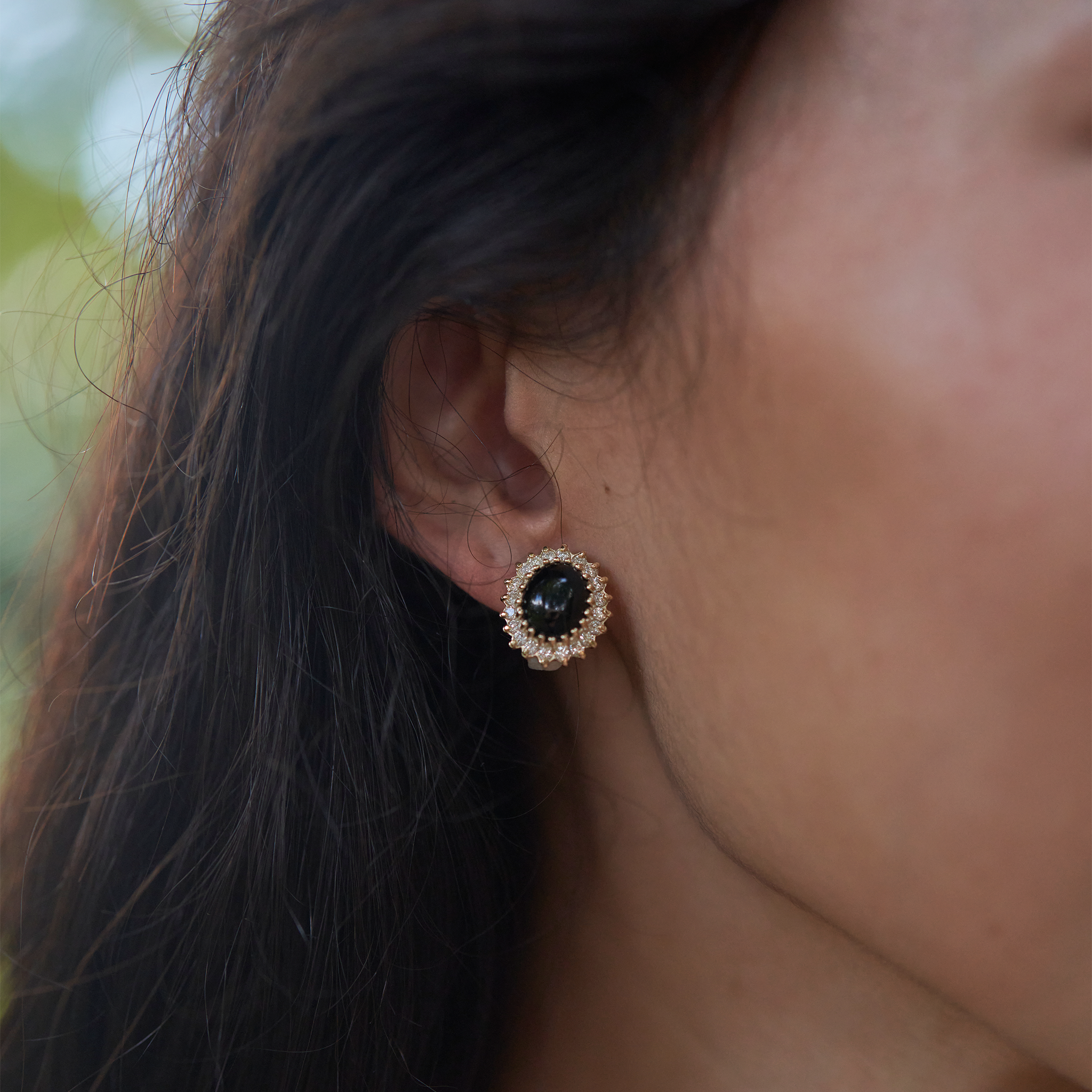 Close up of ear wearing Princess Ka‘iulani Black Coral Earrings in Gold with Diamonds