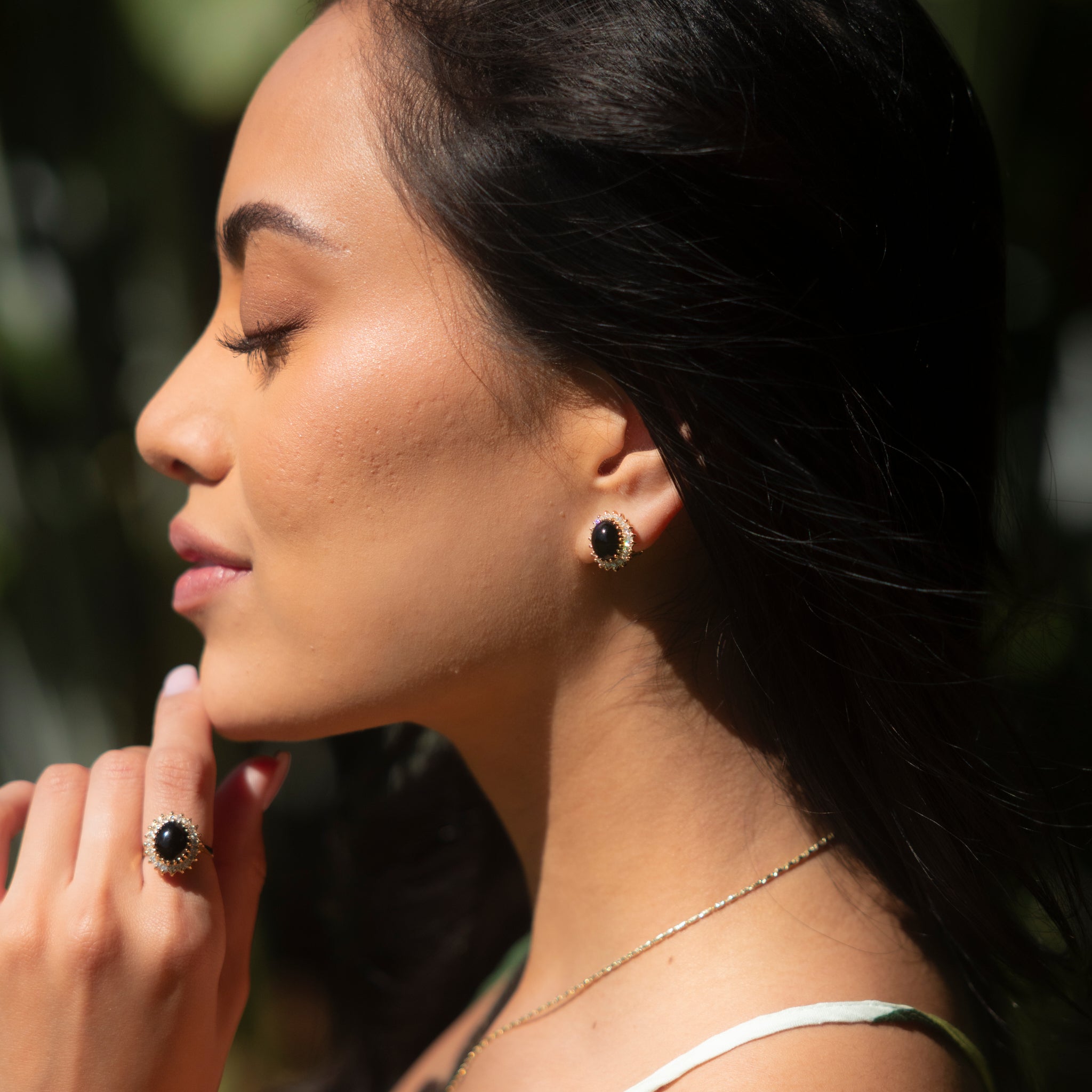 Woman outdoors wearing Princess Ka‘iulani Black Coral Earring and ring in Gold with Diamonds