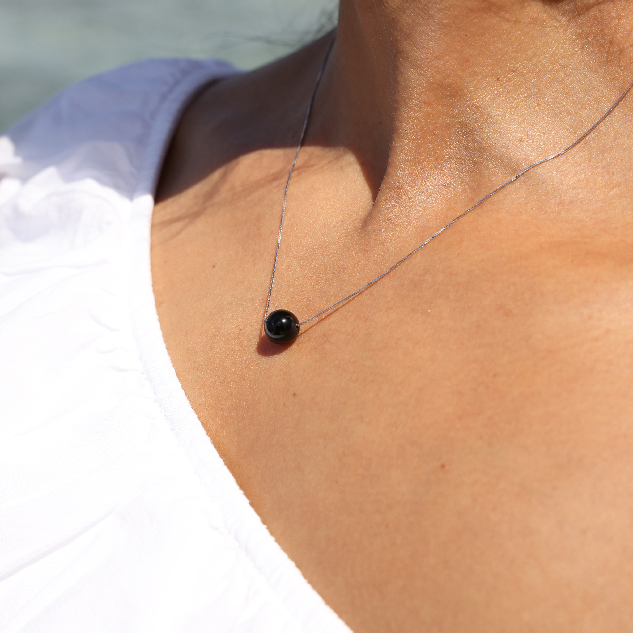 Model Wearing 18" Black Coral Slider Necklace in White Gold outdoors