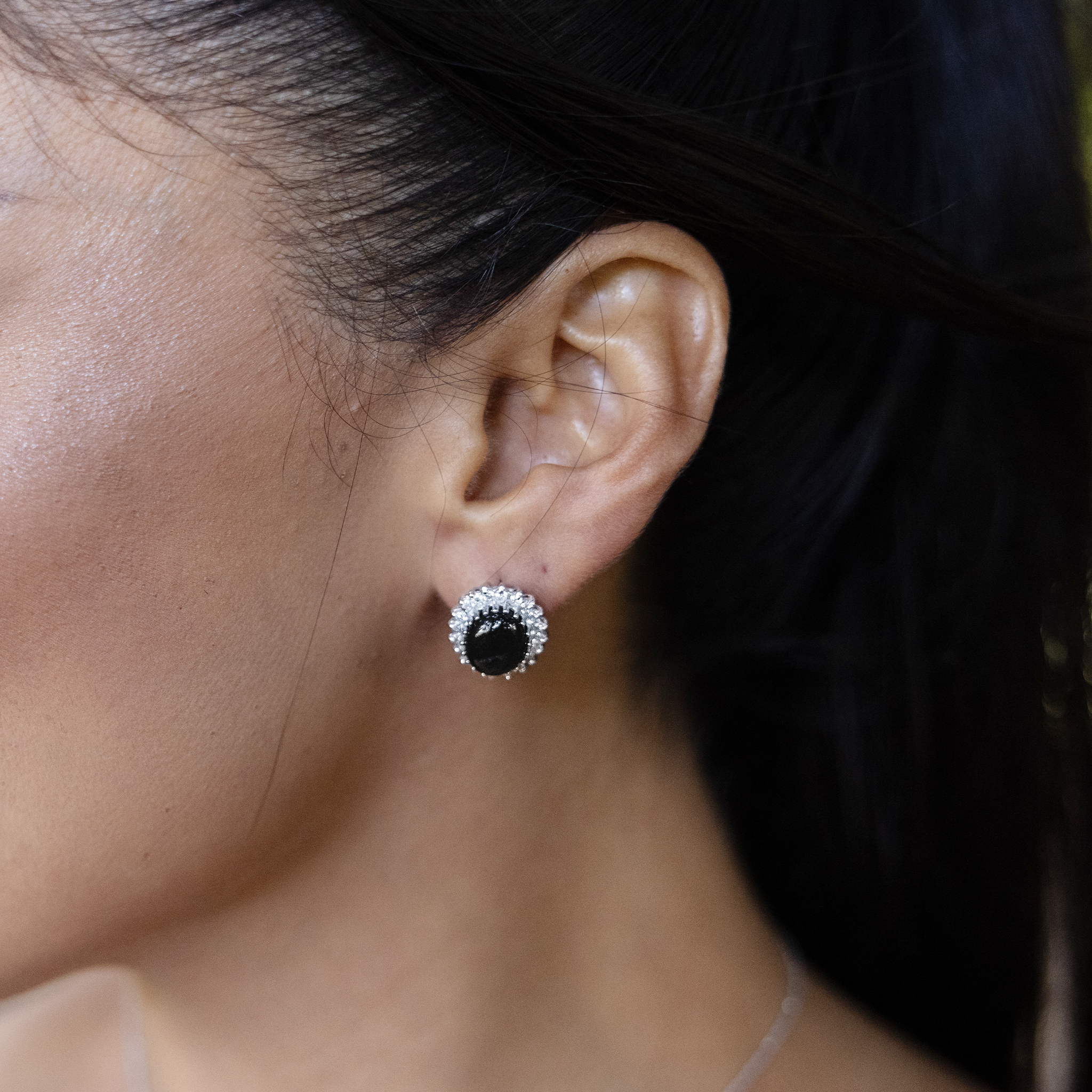 Woman's ear wearing Princess Ka‘iulani Black Coral Earrings in White Gold with Diamonds
