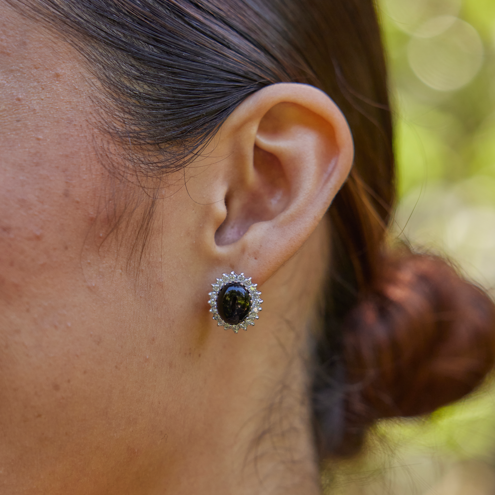 Woman's ear wearing Princess Ka‘iulani Black Coral Earrings in White Gold with Diamonds