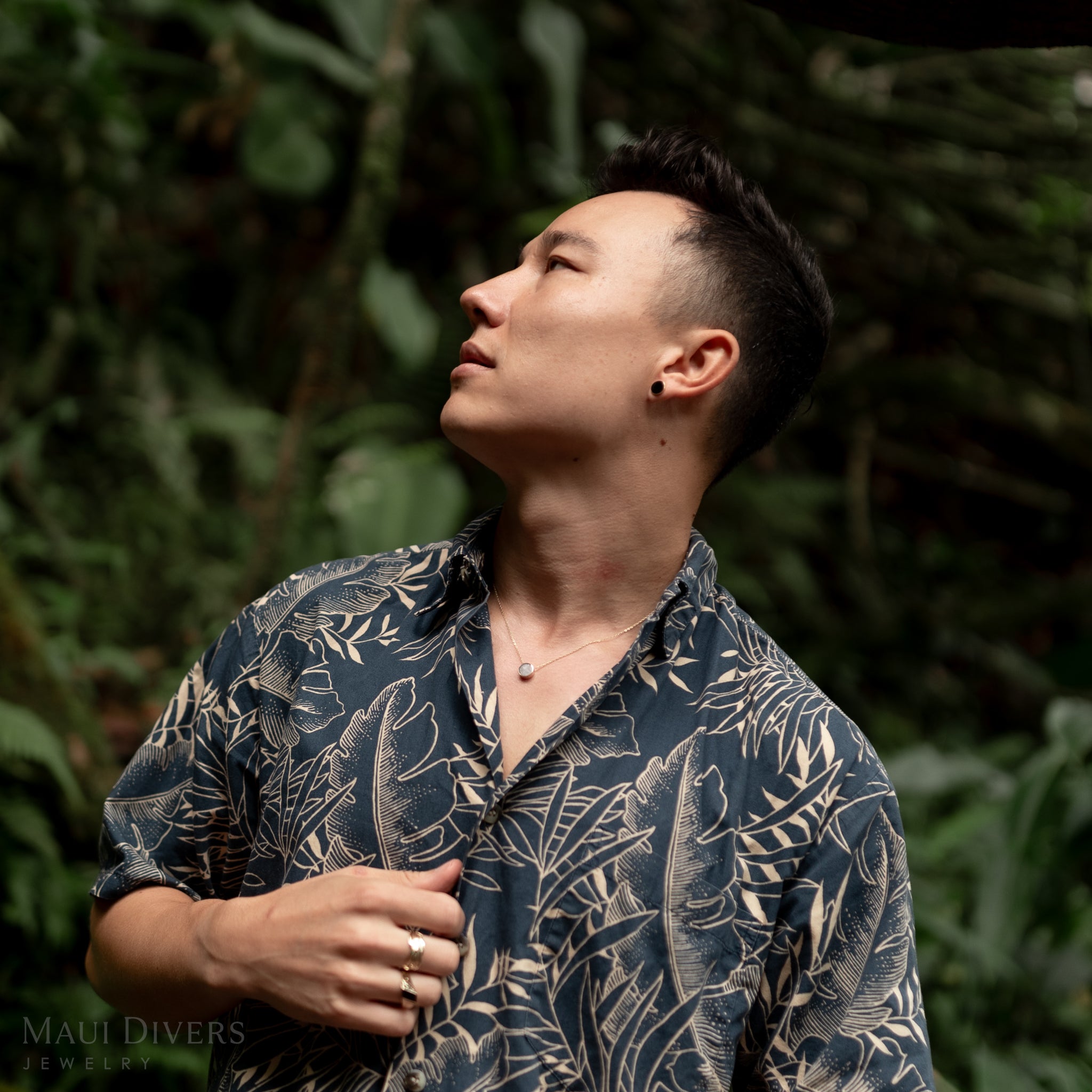 Man in forest wearing Eclipse Flipside Black Coral & Mother of Pearl Necklace in Gold