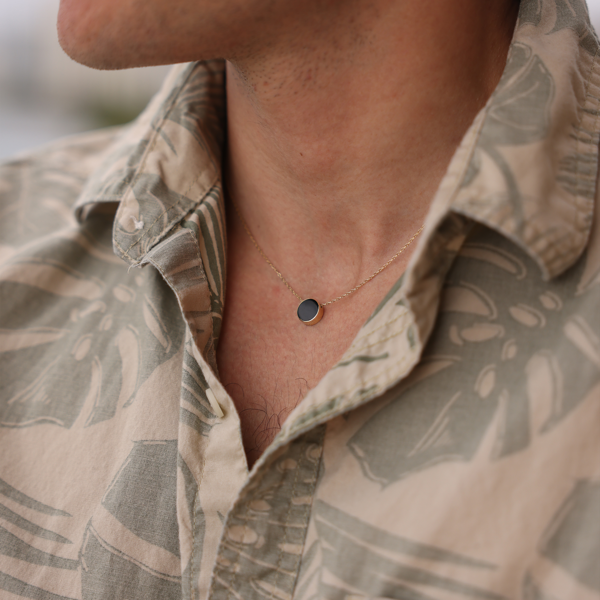 Close up of Eclipse Flipside Black Coral & Mother of Pearl Necklace in Gold on man's neckline