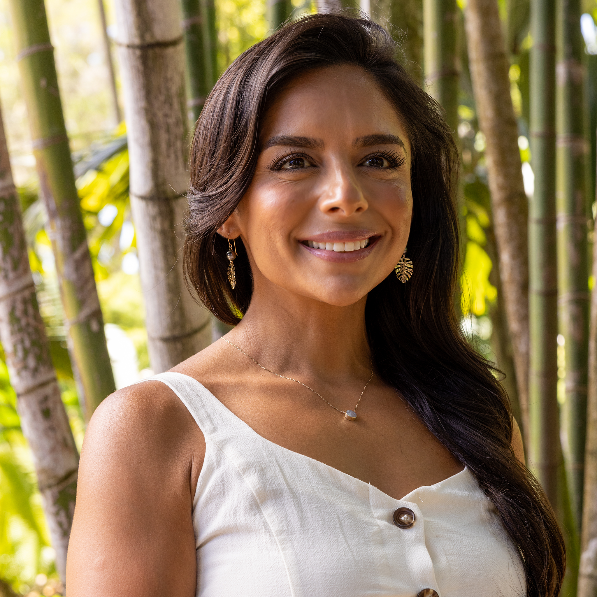 Woman in bamboo forest wearing Eclipse Flipside Black Coral & Mother of Pearl Necklace in Gold