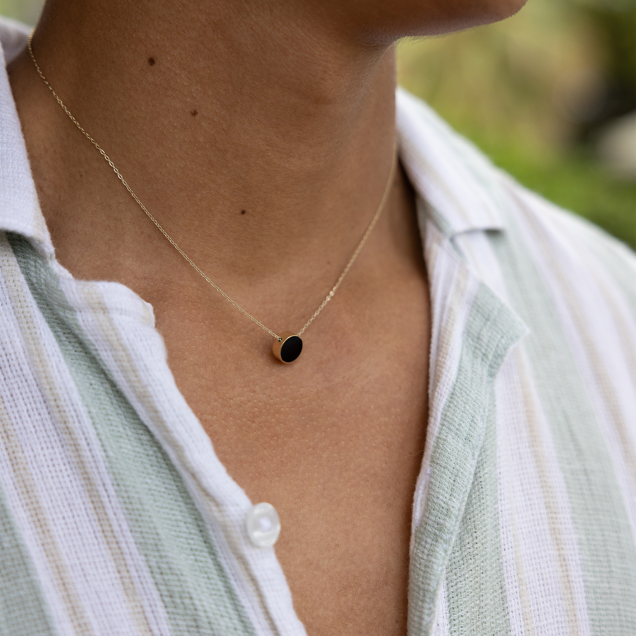 Close up of Eclipse Flipside Black Coral & Mother of Pearl Necklace in Gold on man's neckline
