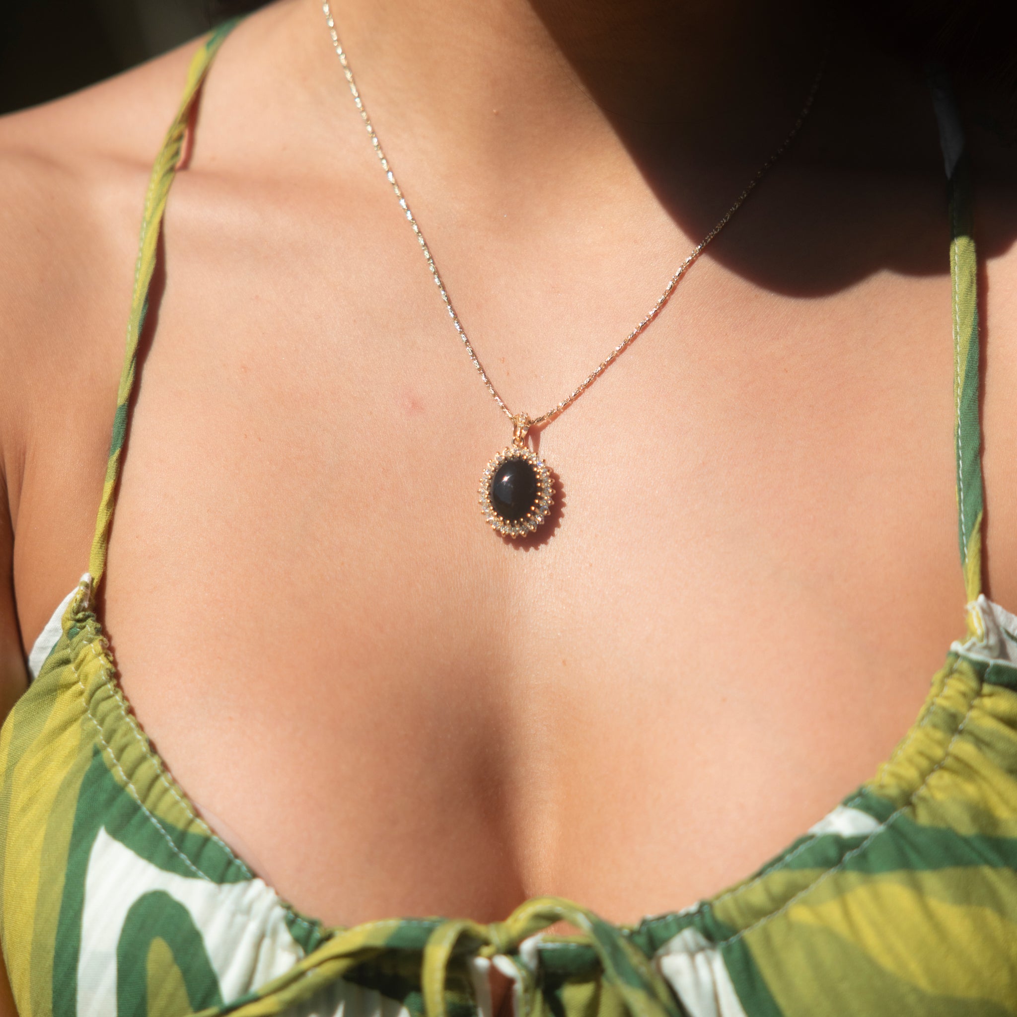 Close up of Princess Ka‘iulani Black Coral Pendant in Gold with Diamonds on woman's chest
