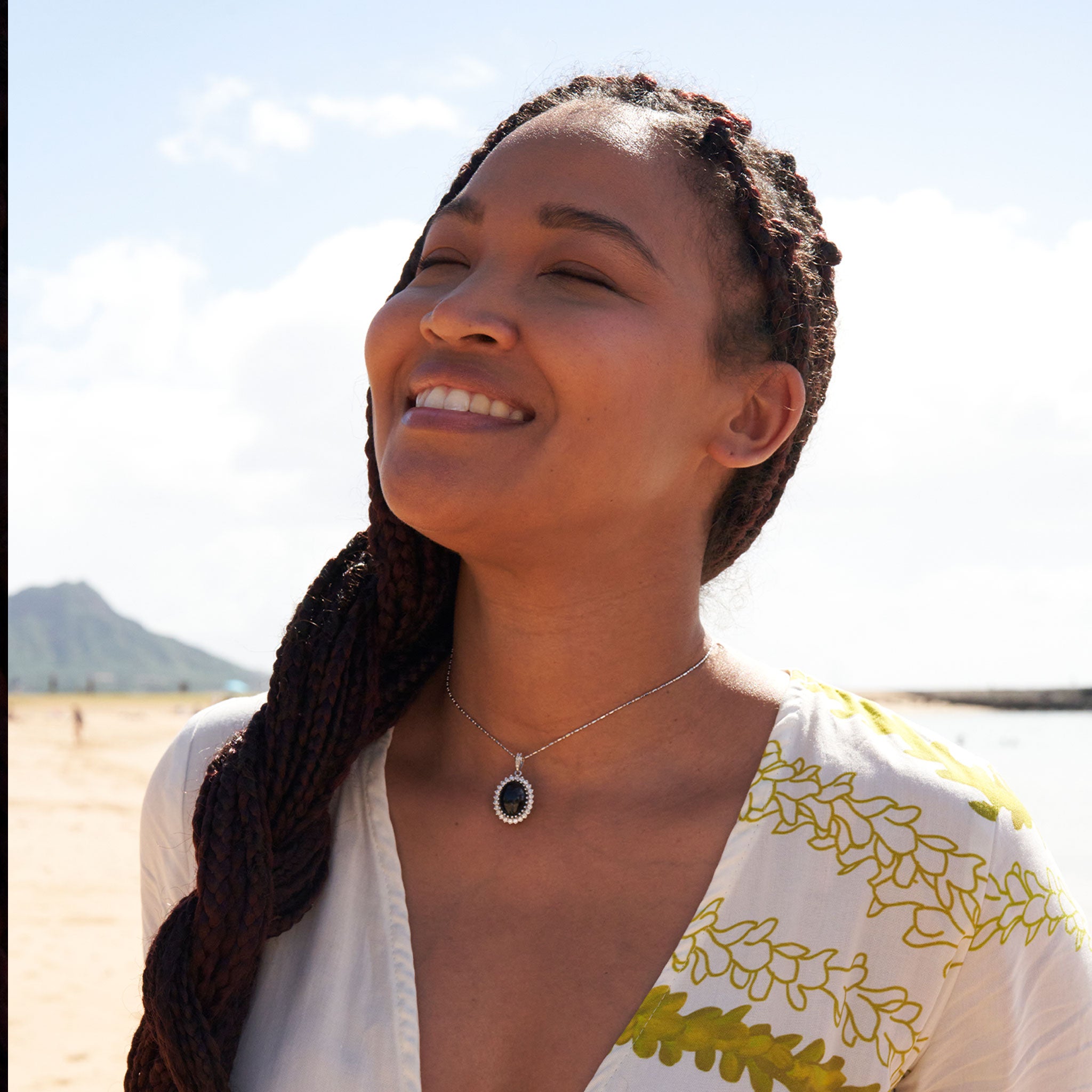 Woman on beach wearing Princess Ka‘iulani Black Coral Pendant in White Gold with Diamonds