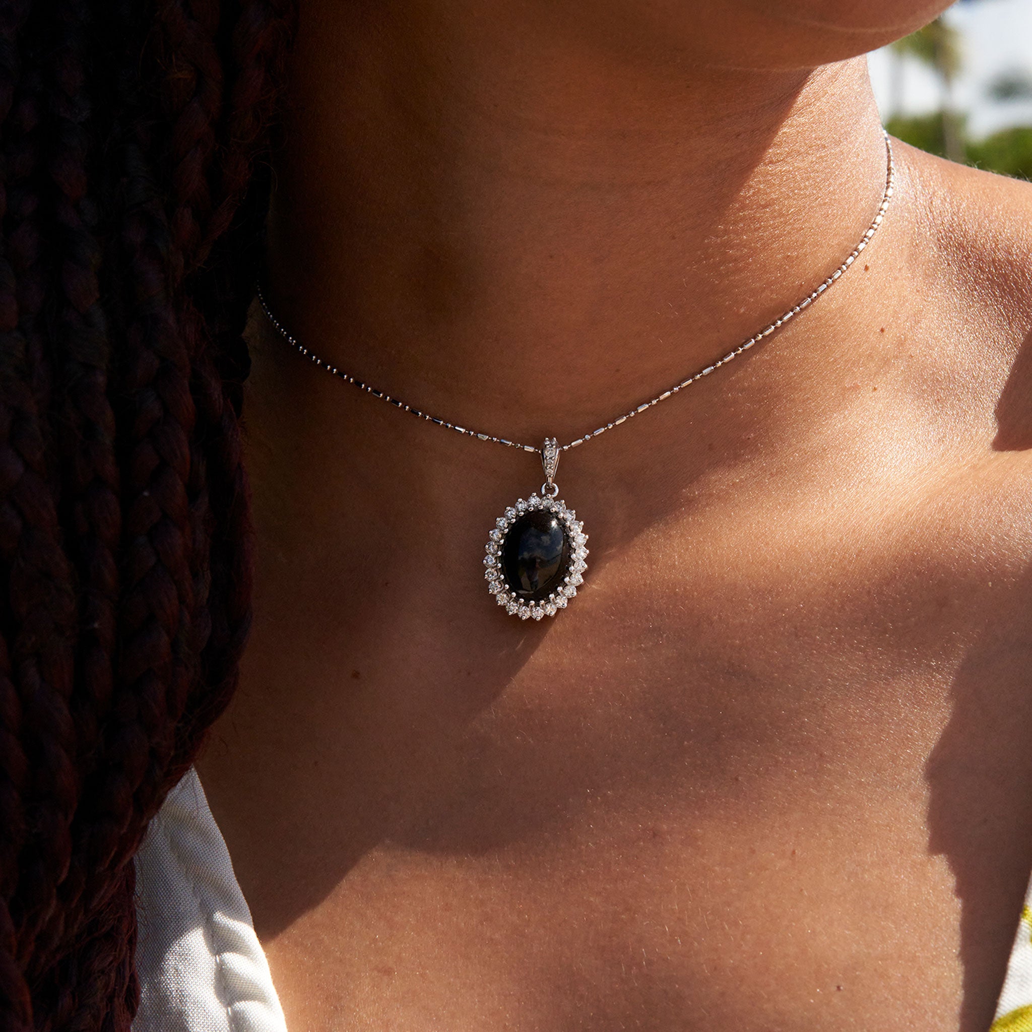 Close up of Princess Ka‘iulani Black Coral Pendant in White Gold with Diamonds on woman's neckline