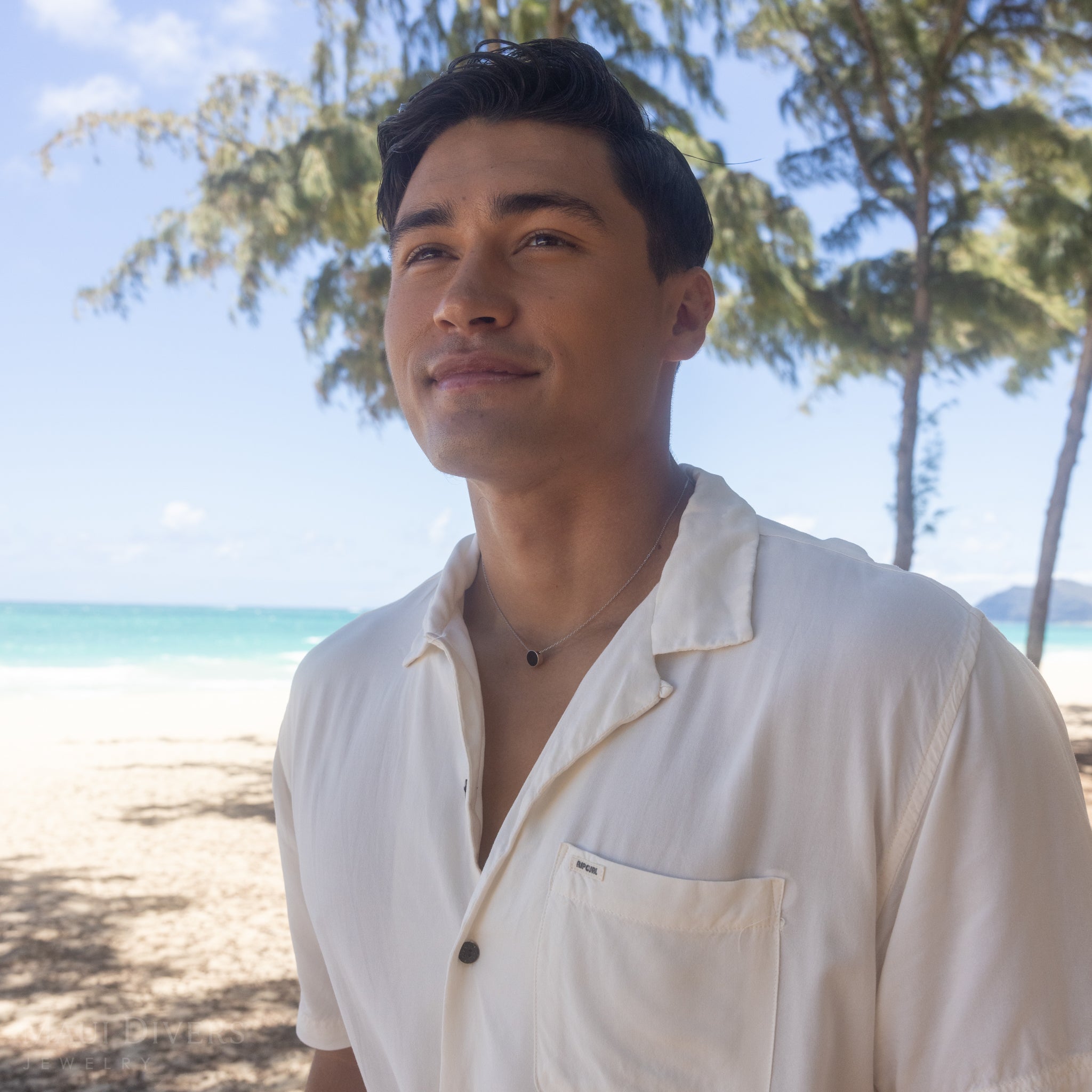 Man on beach wearing Eclipse Flipside Black Coral Necklace in White Gold