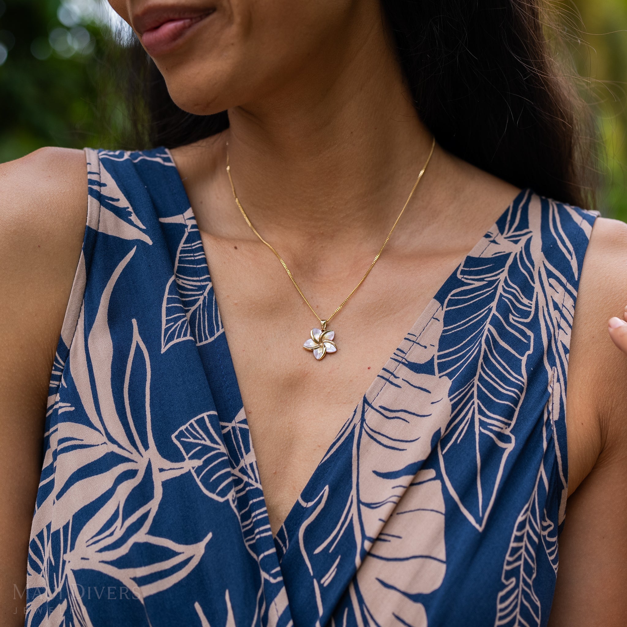 Close up of Plumeria Mother of Pearl Pendant in 14k Yellow Gold on woman's chest