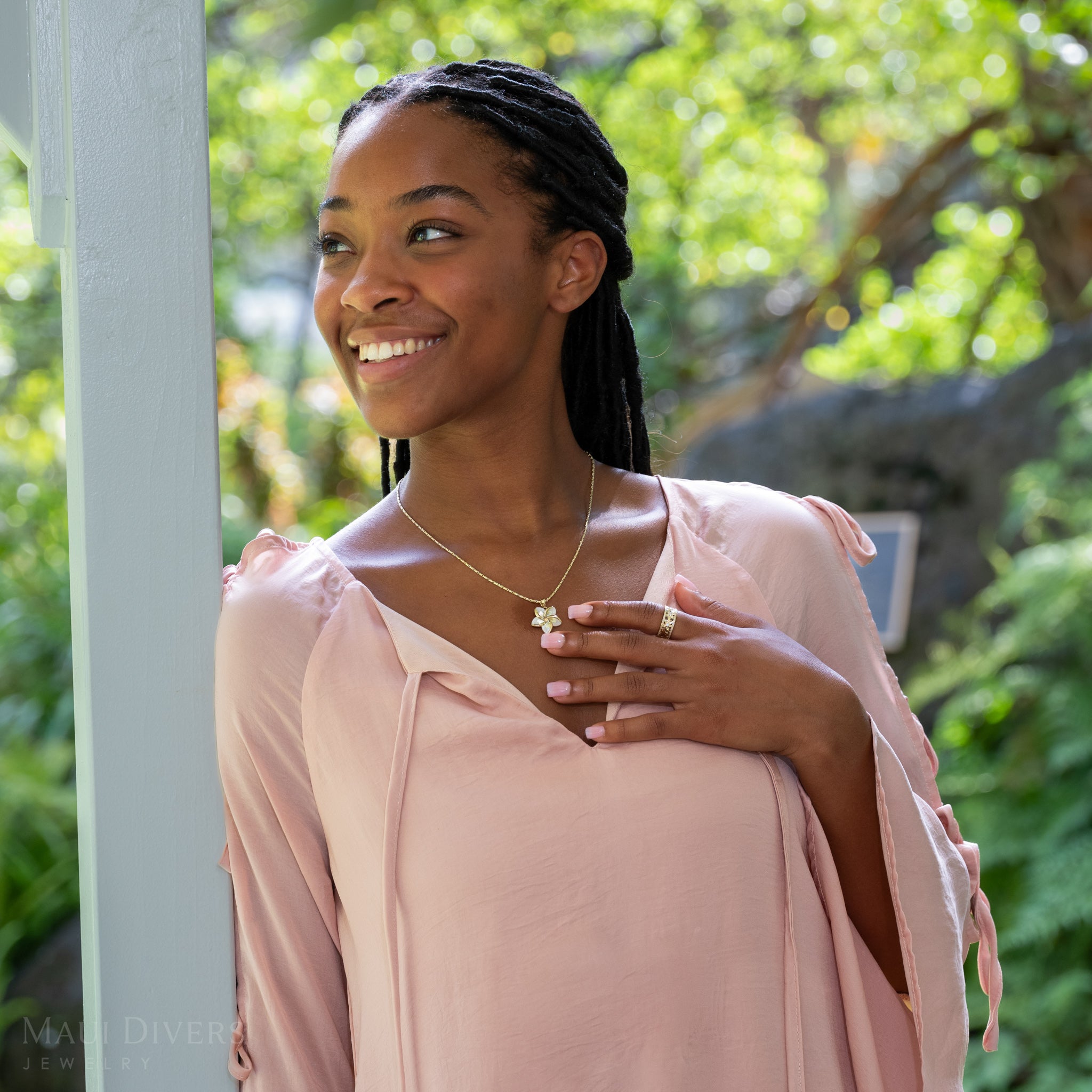 Woman outdoors wearing Plumeria Mother of Pearl Pendant in 14k Yellow Gold