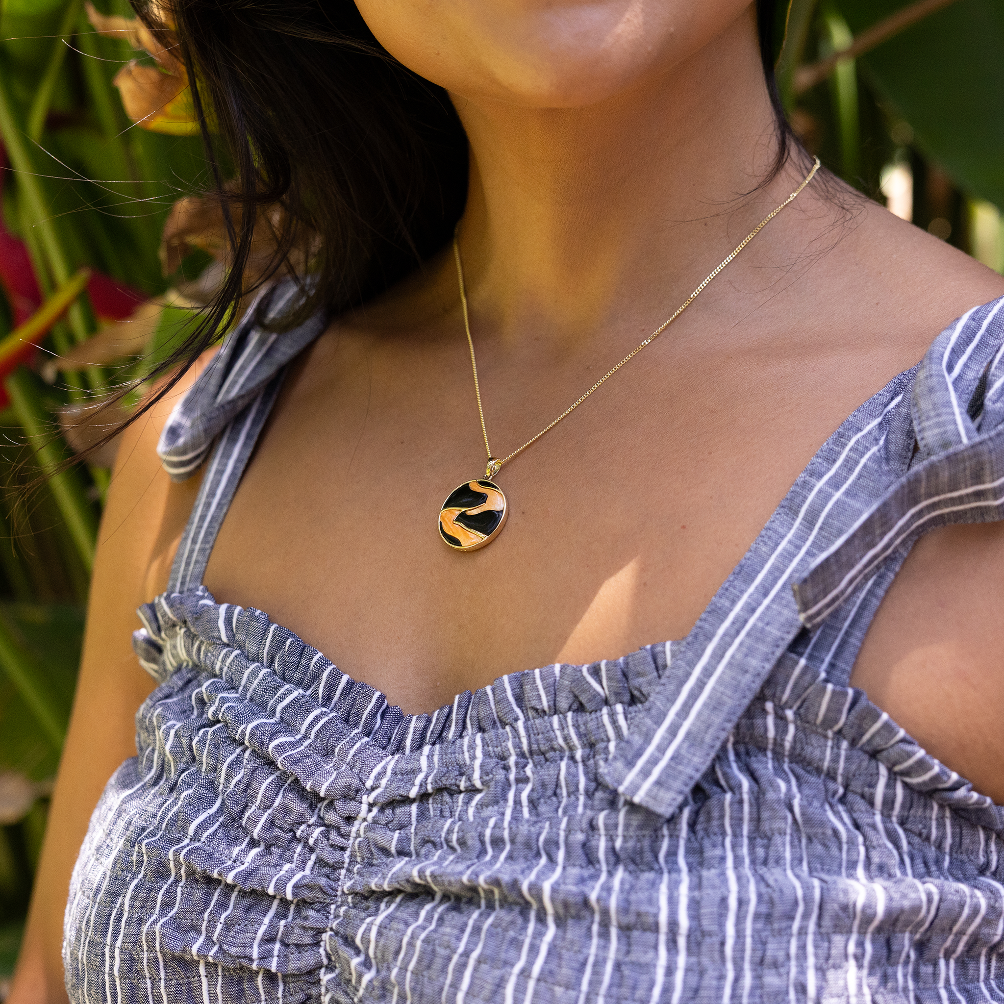 Close up of Lava Flow Black Coral and Spiny Oyster Pendant on woman's chest