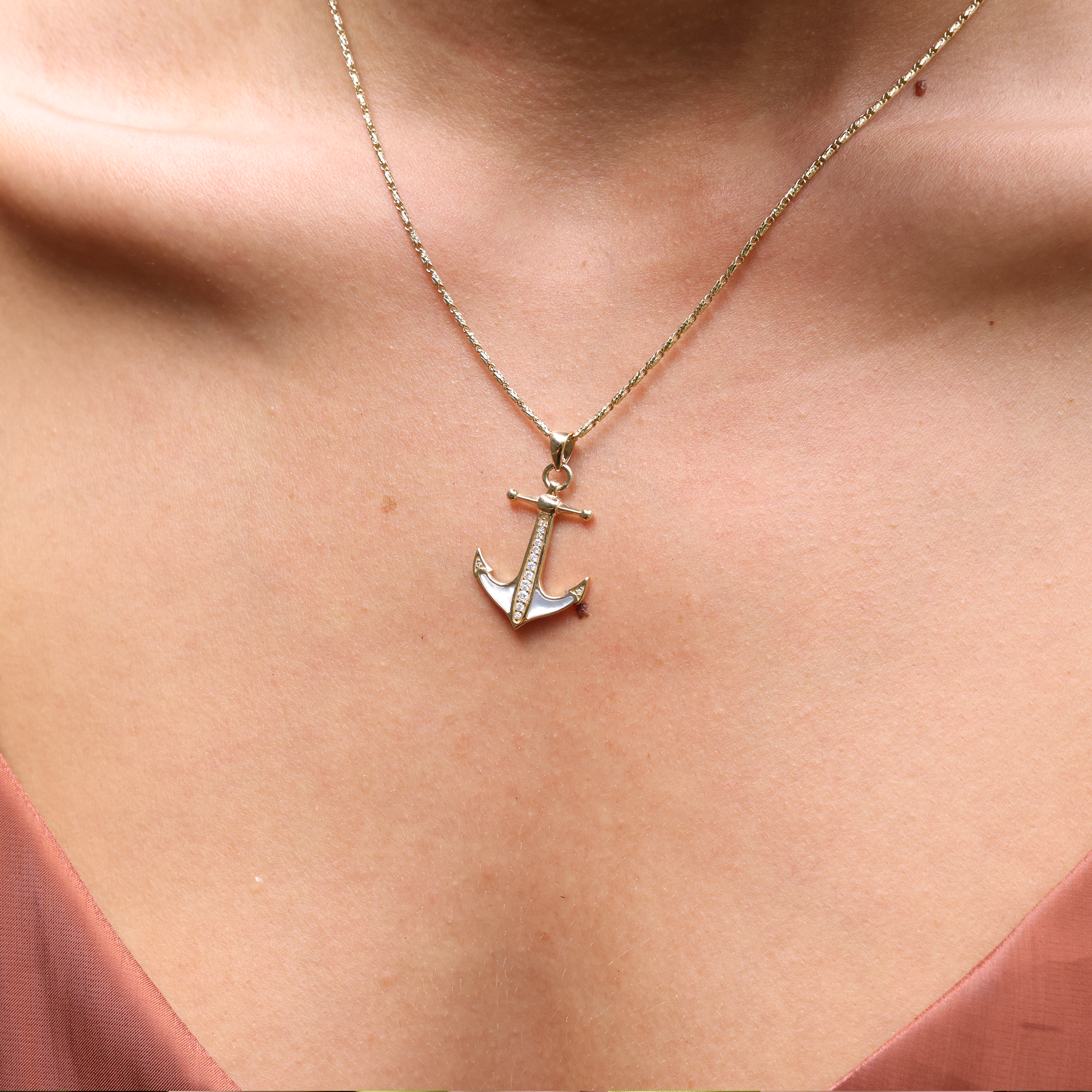 Close up of 1.4mm Raso Chain in Gold and an anchor pendant on a person's chest