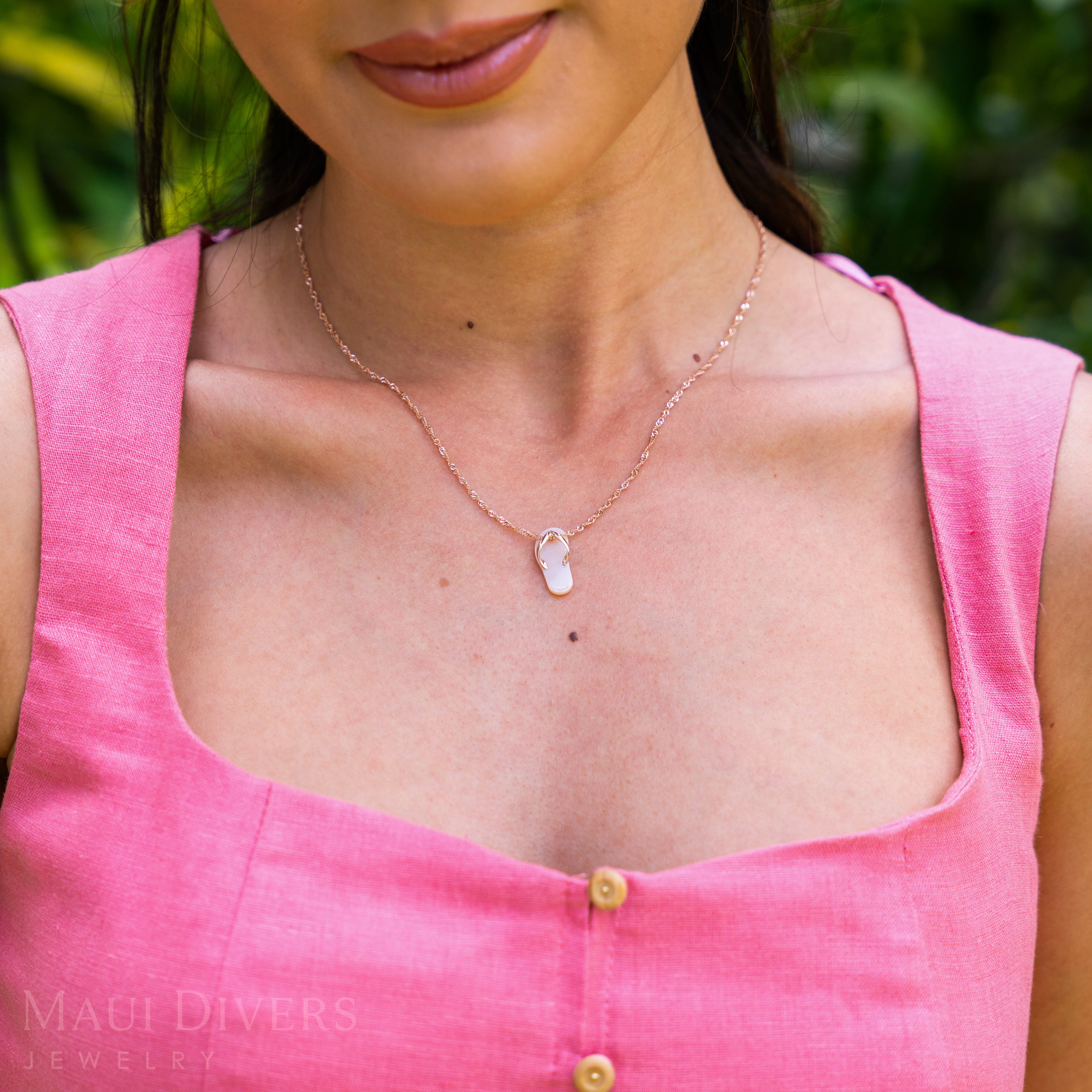 Woman wearing a pink sleeveless top and Pink Mother of Pearl Slipper Pendant with Rose Gold straps outdoors