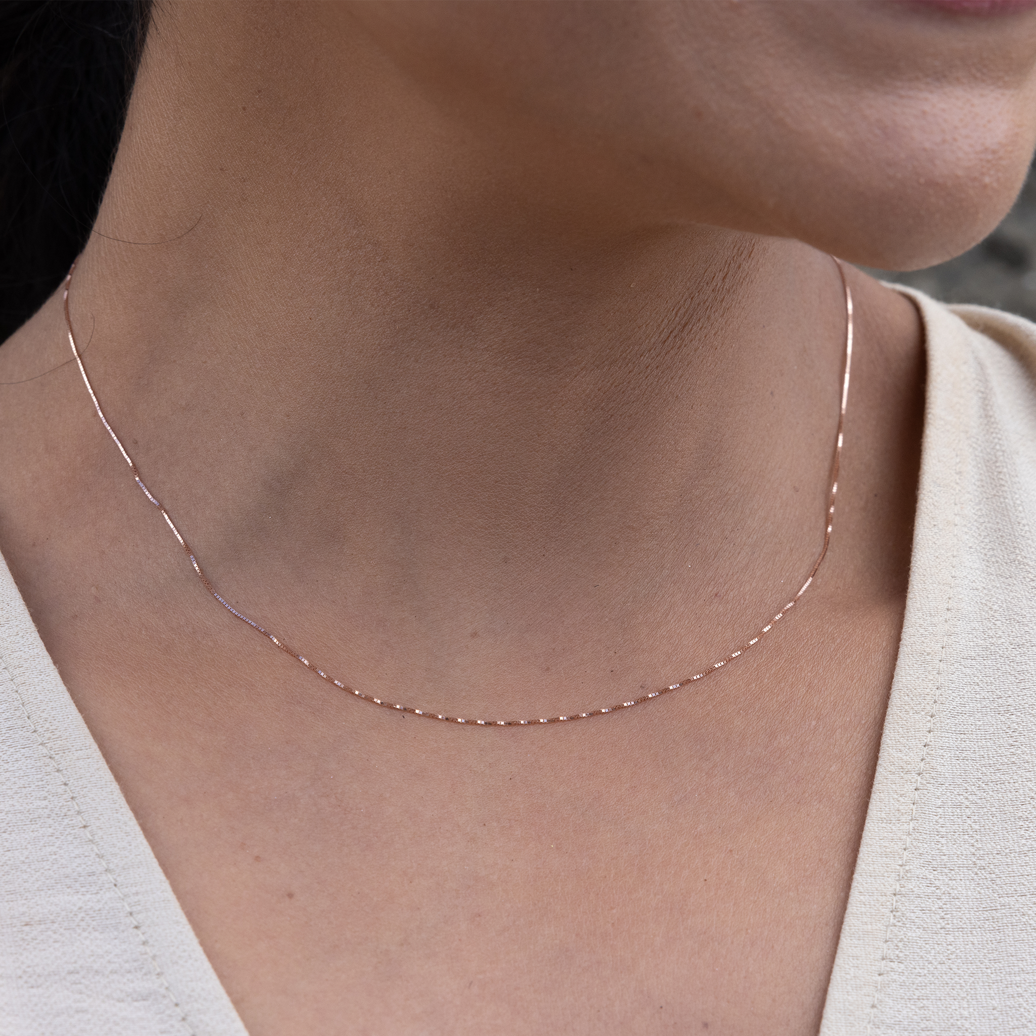 Close up of 0.45mm Box Chain in 10k Rose Gold on woman's neckline