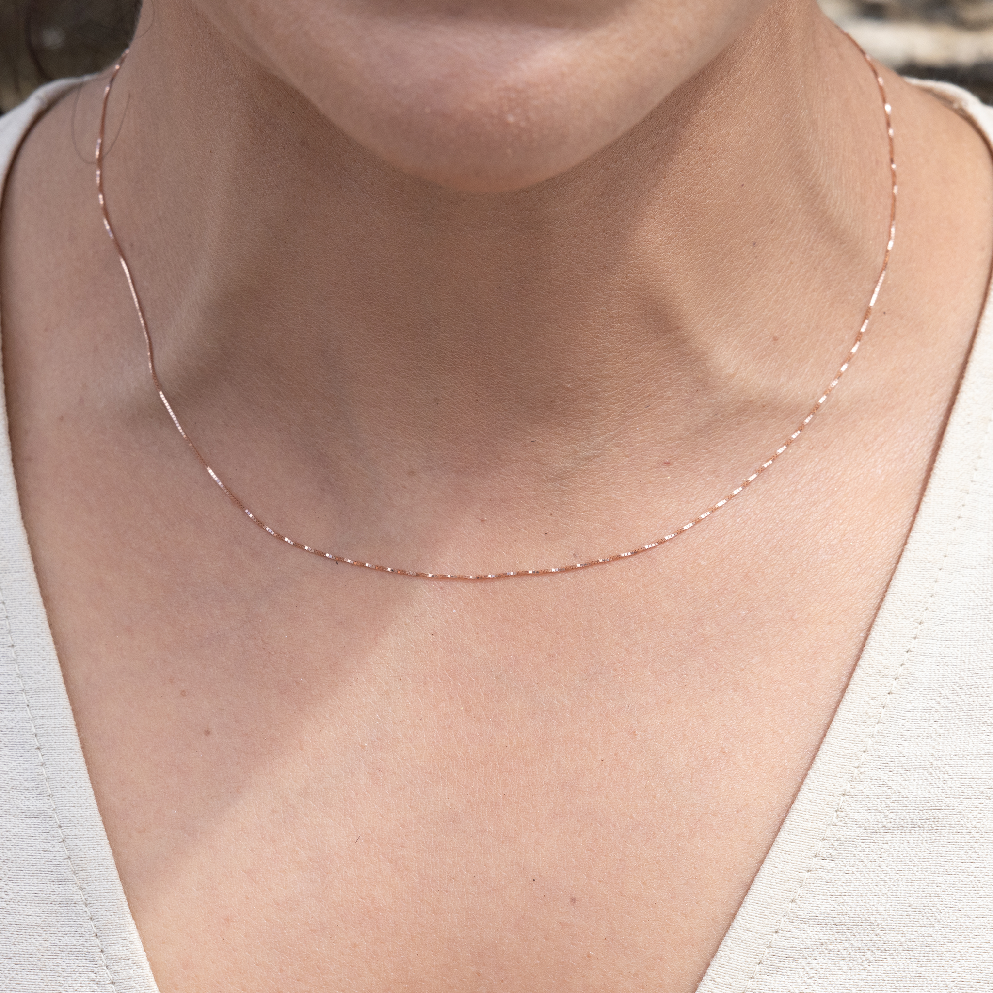 Close up of 0.45mm Box Chain in 10k Rose Gold on woman's neckline