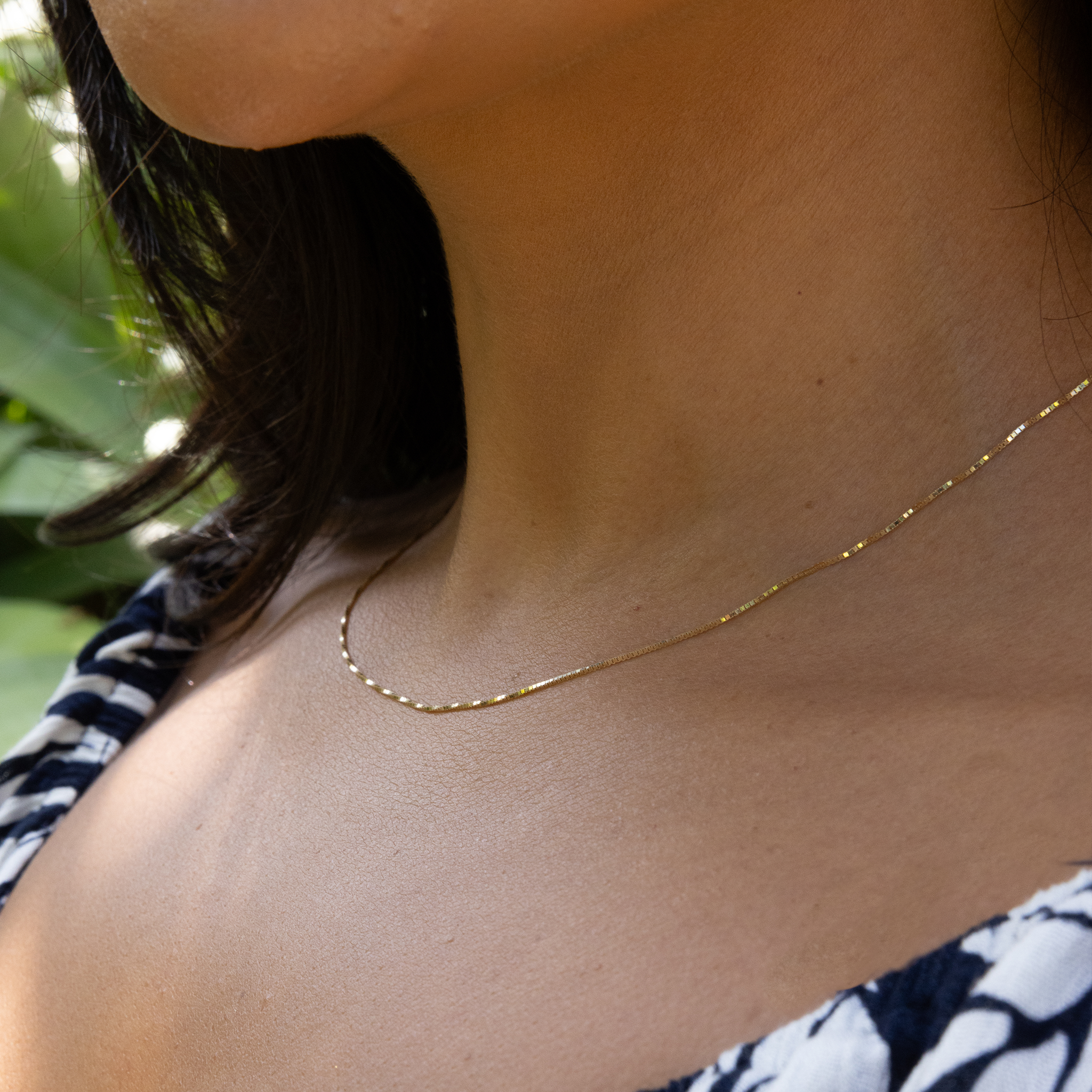 Close up woman wearing 0.8mm Venetian Box Chain in Gold