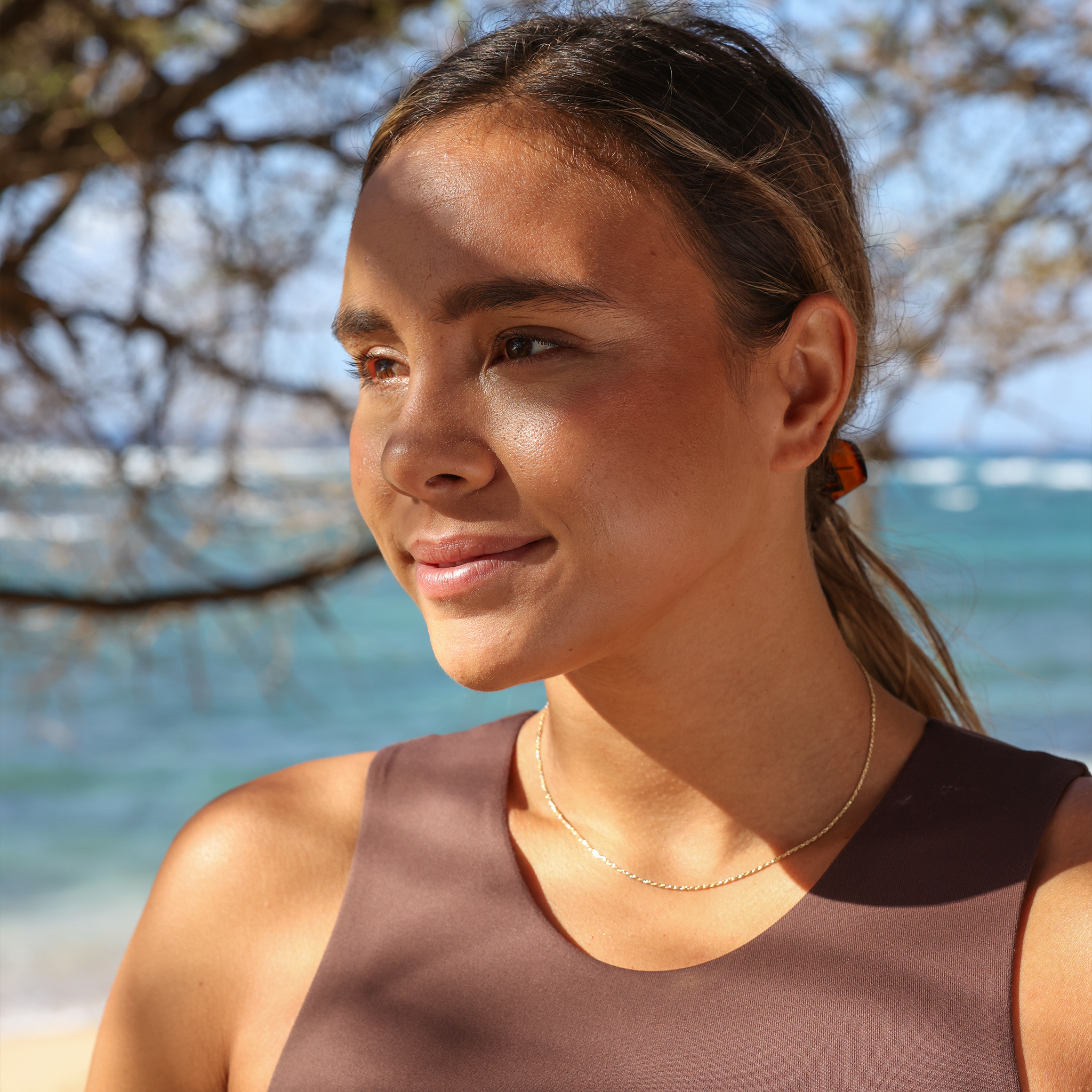 Woman at the beach wearing 1.2mm Flex Rope Chain in Gold