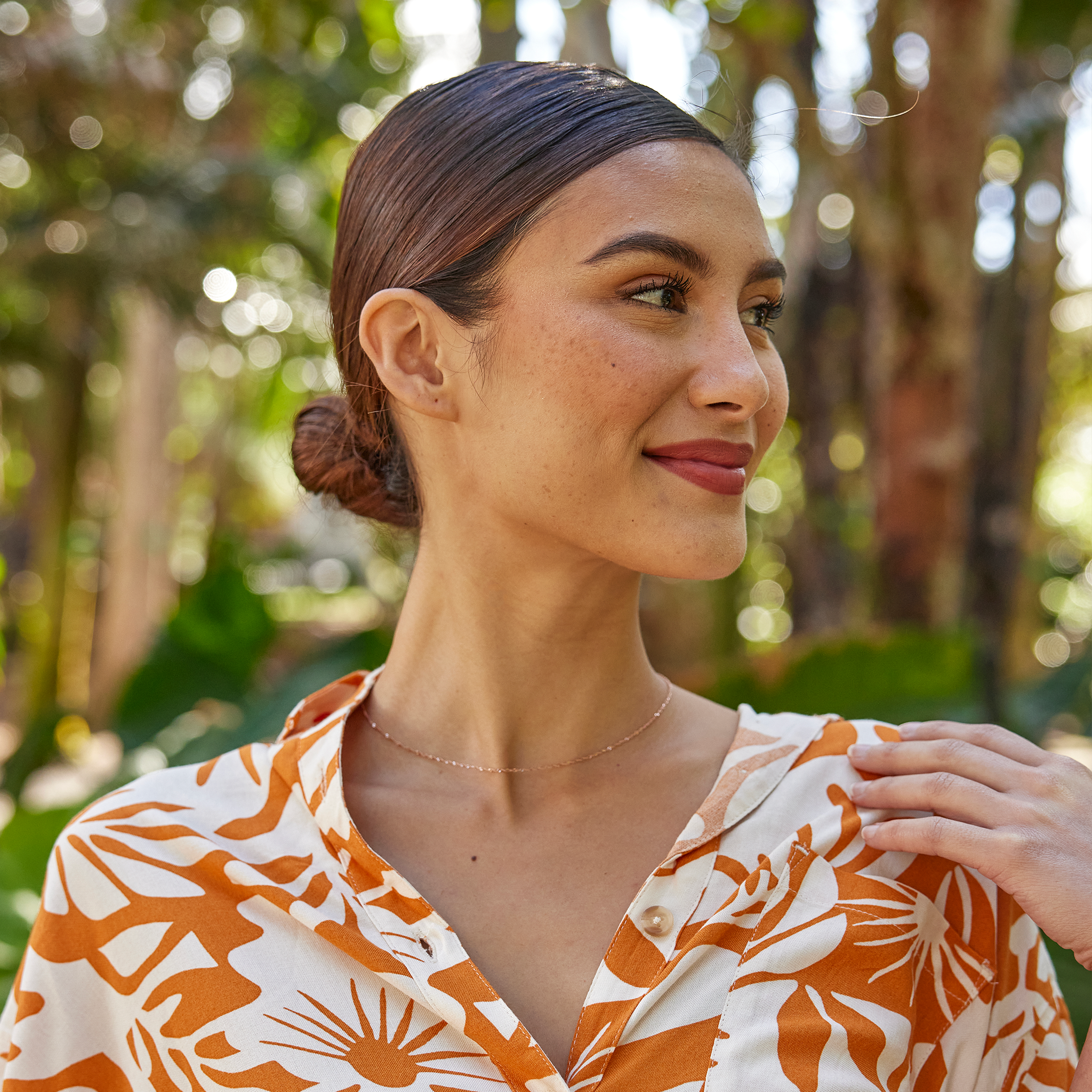 Woman in a garden wearing 1.0mm Singapore Chain in Rose Gold