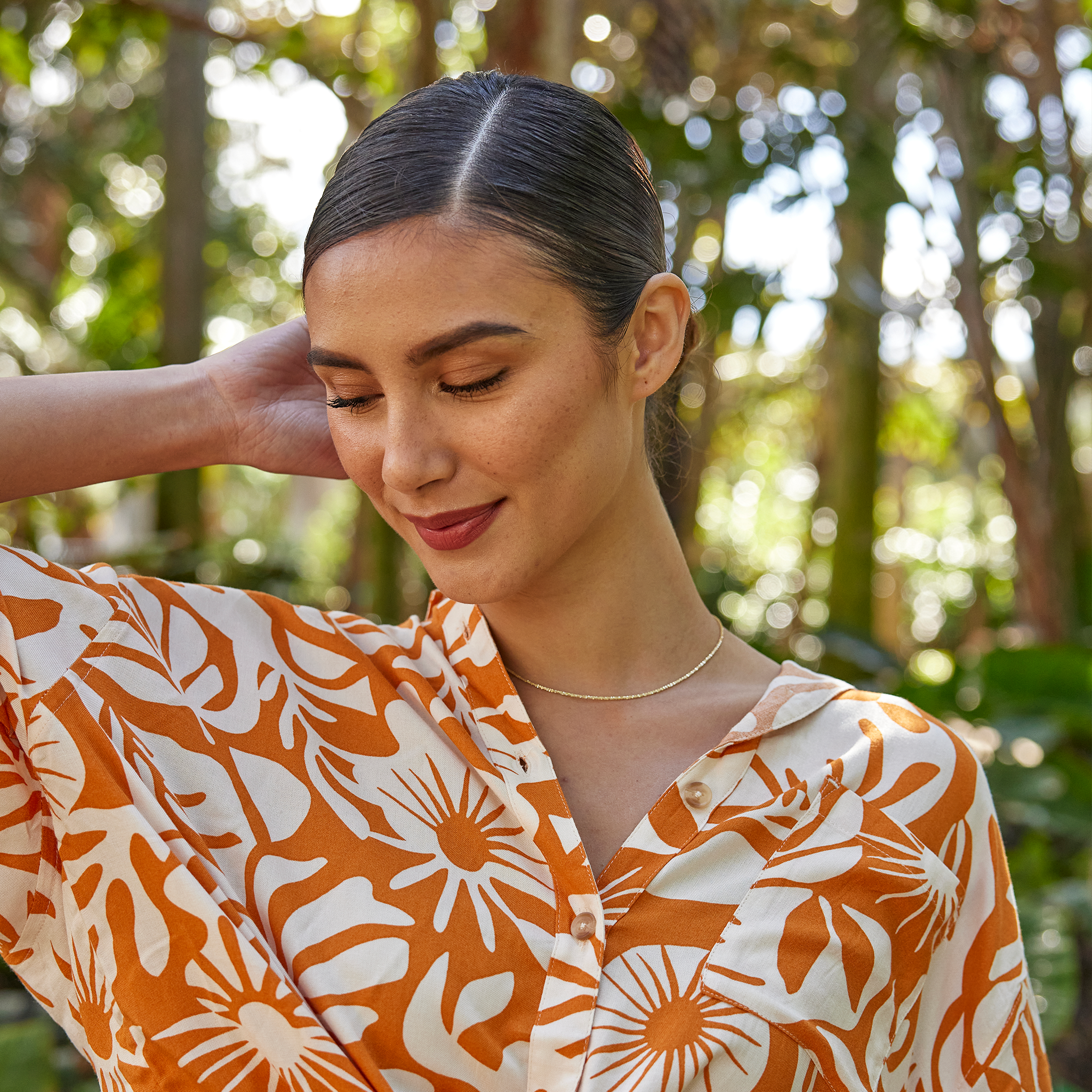 Woman in a garden wearing 1.0mm Margarita Chain in Gold and an orange and white floral printed top