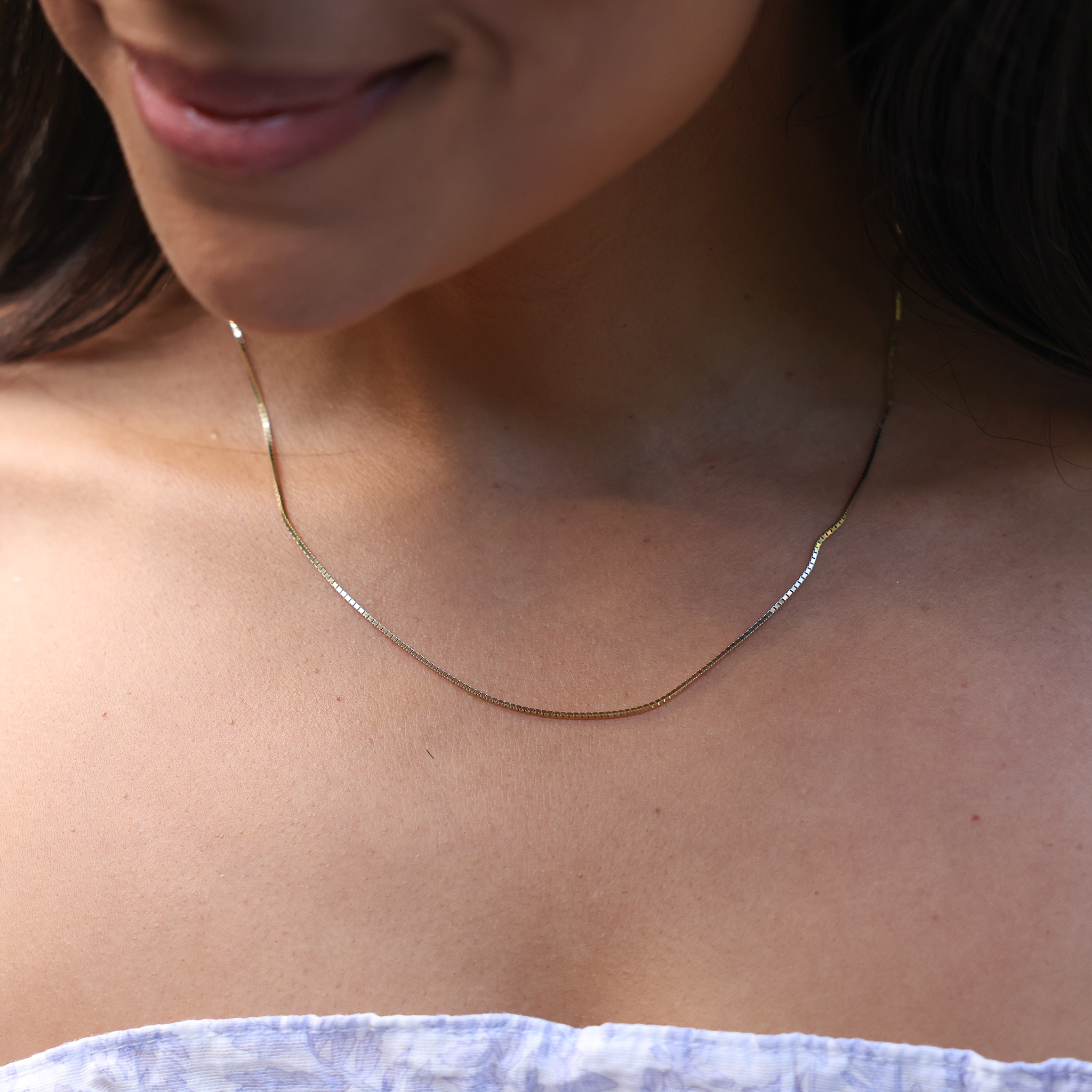 Close up of 1.0mm Box Chain in Gold on woman's chest