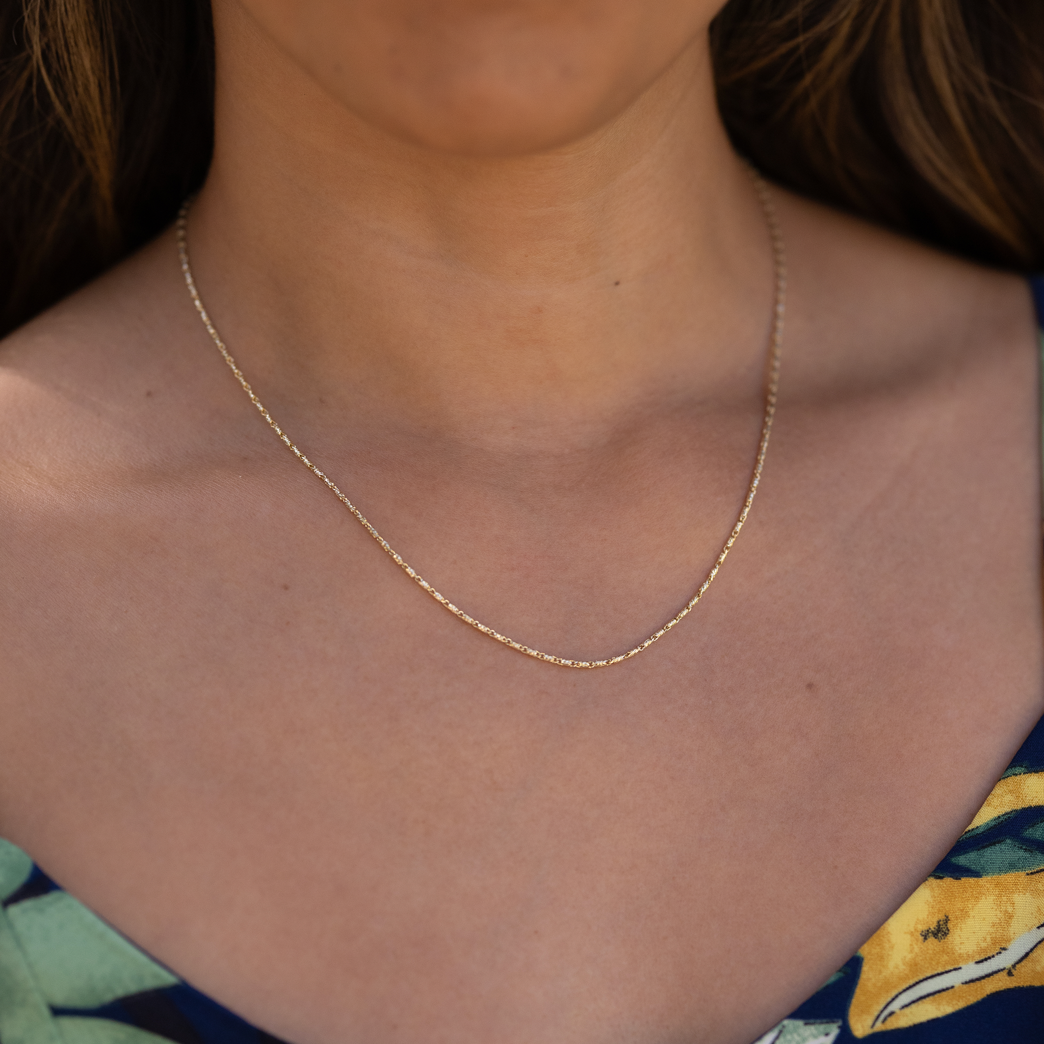 Close up of 1.4mm Raso Chain in Gold on a person's chest