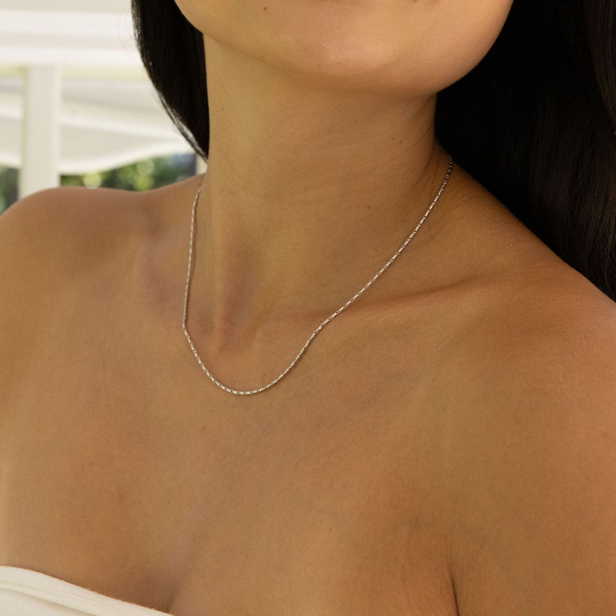 Woman's neckline wearing 1.4mm Raso Chain in White Gold