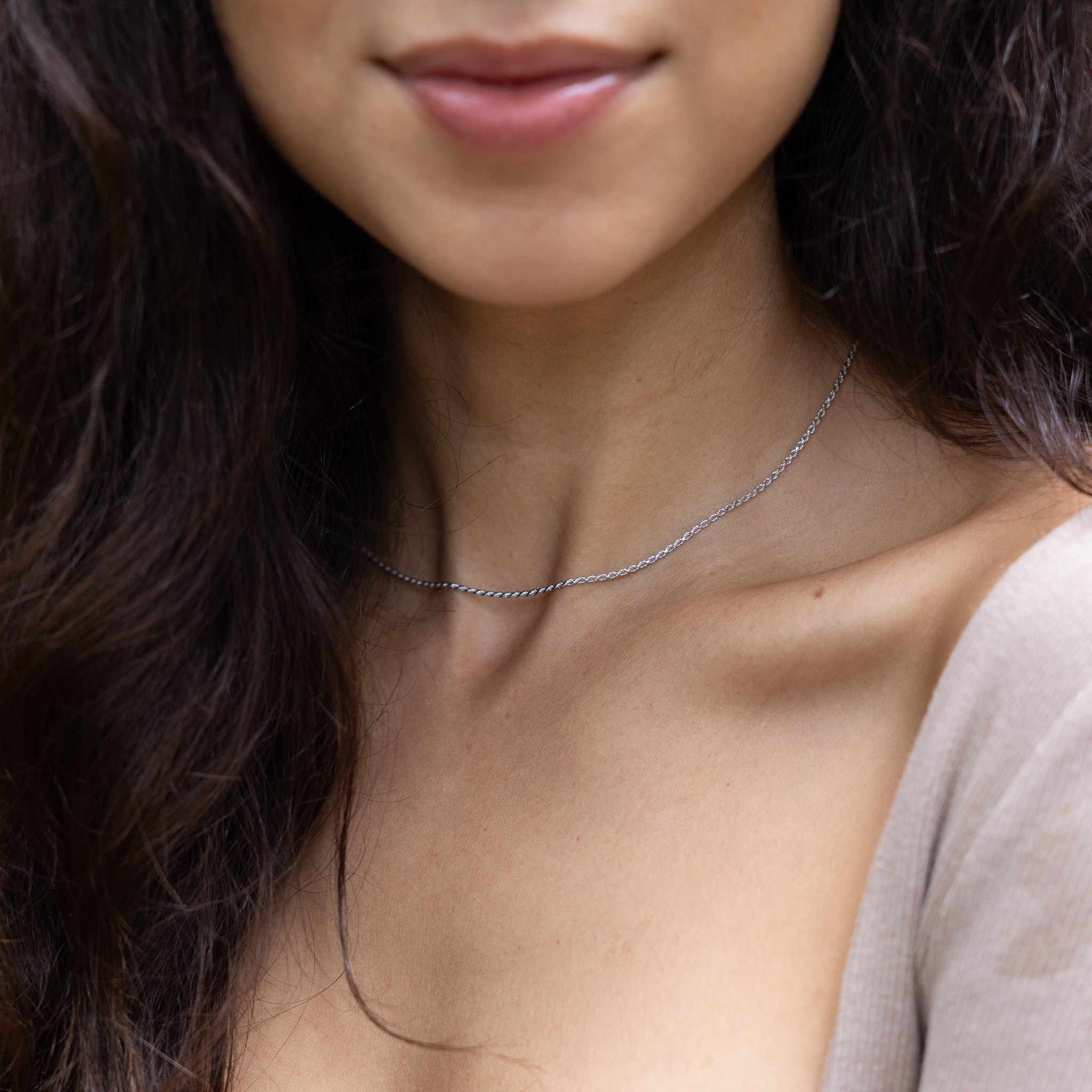 Close up of 1.2mm Flex Rope Chain in White Gold on a woman's neckline partially covered by hair