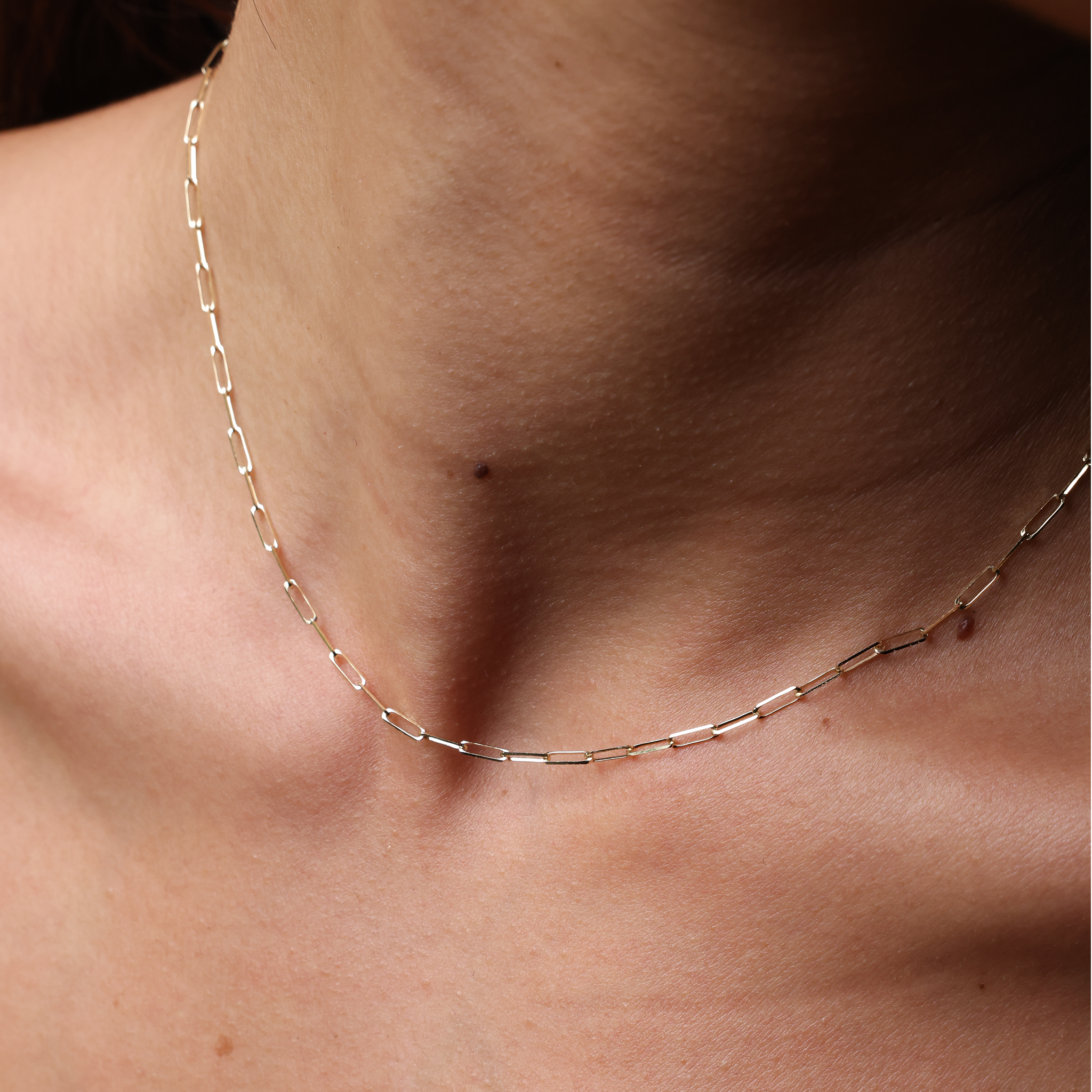 Close up of a woman's neck wearing 2mm Paperclip Chain in Gold