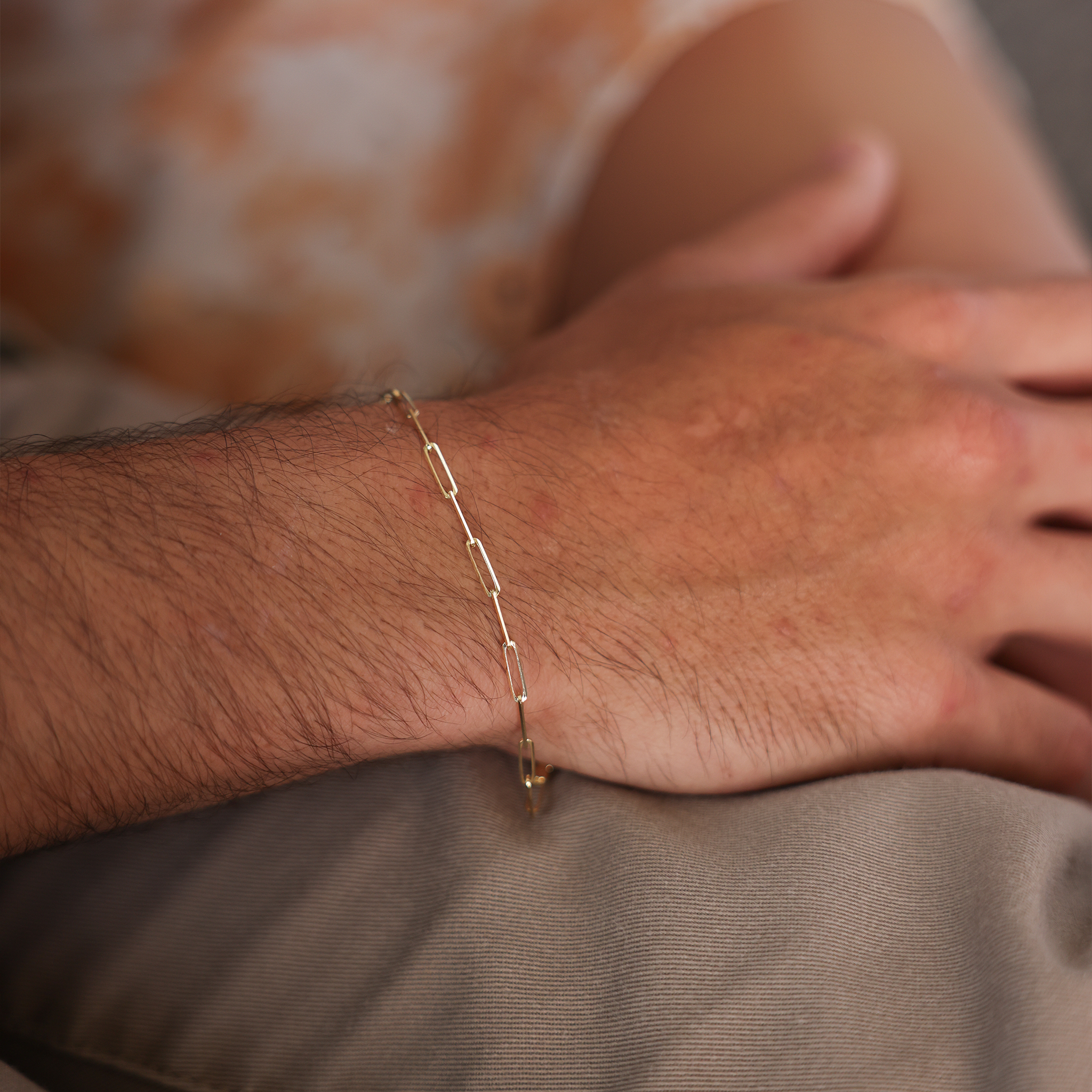 Close up of 2.7mm Paperclip Chain Bracelet in 14k Yellow Gold on a man's wrist