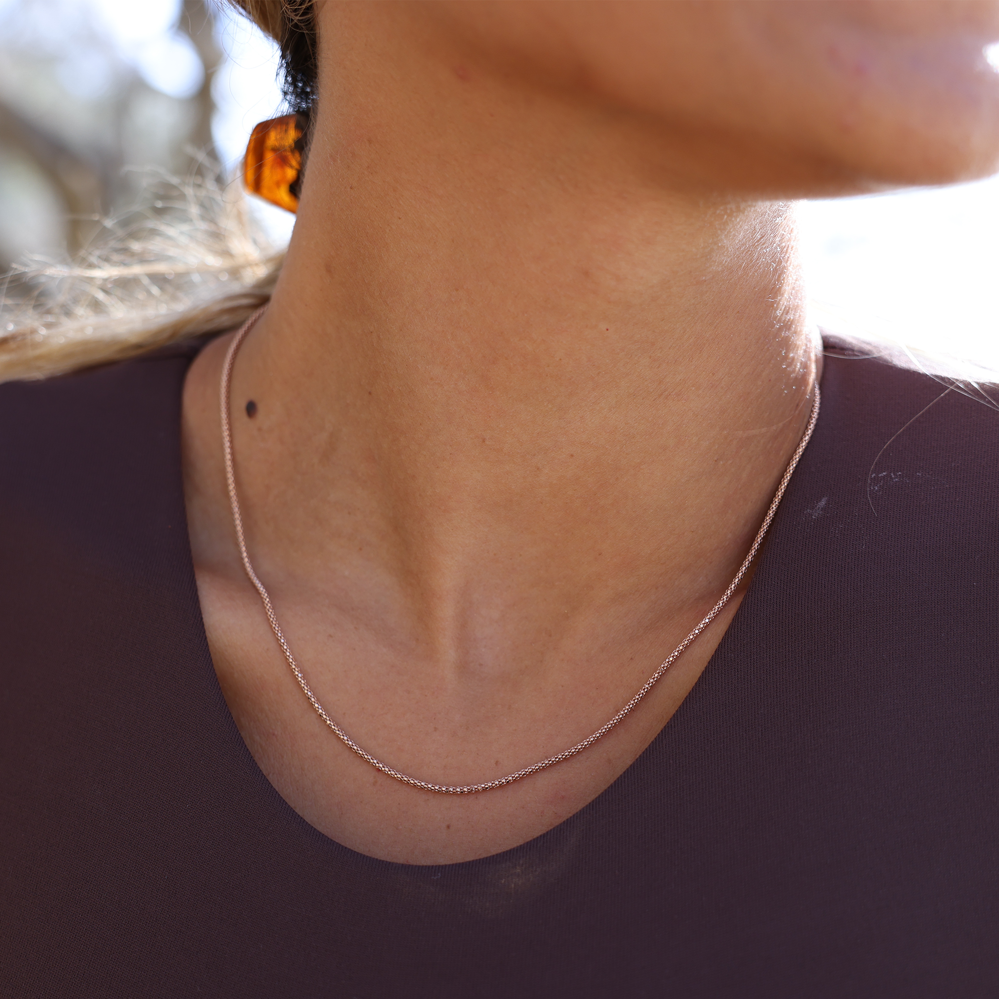 Close up of 1.6mm Popcorn Chain in 14k Rose Gold on a personʻs neck