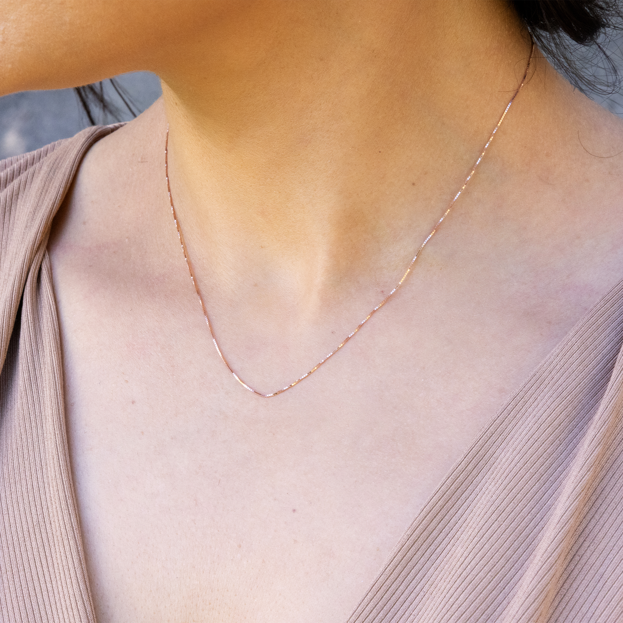 Close up of 0.6mm Lite Box Chain in 14k Rose Gold on a personʻs chest